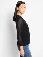 Black mesh knit cardigan with an open weave texture and 3/4 length sleeves, modeled on a person.