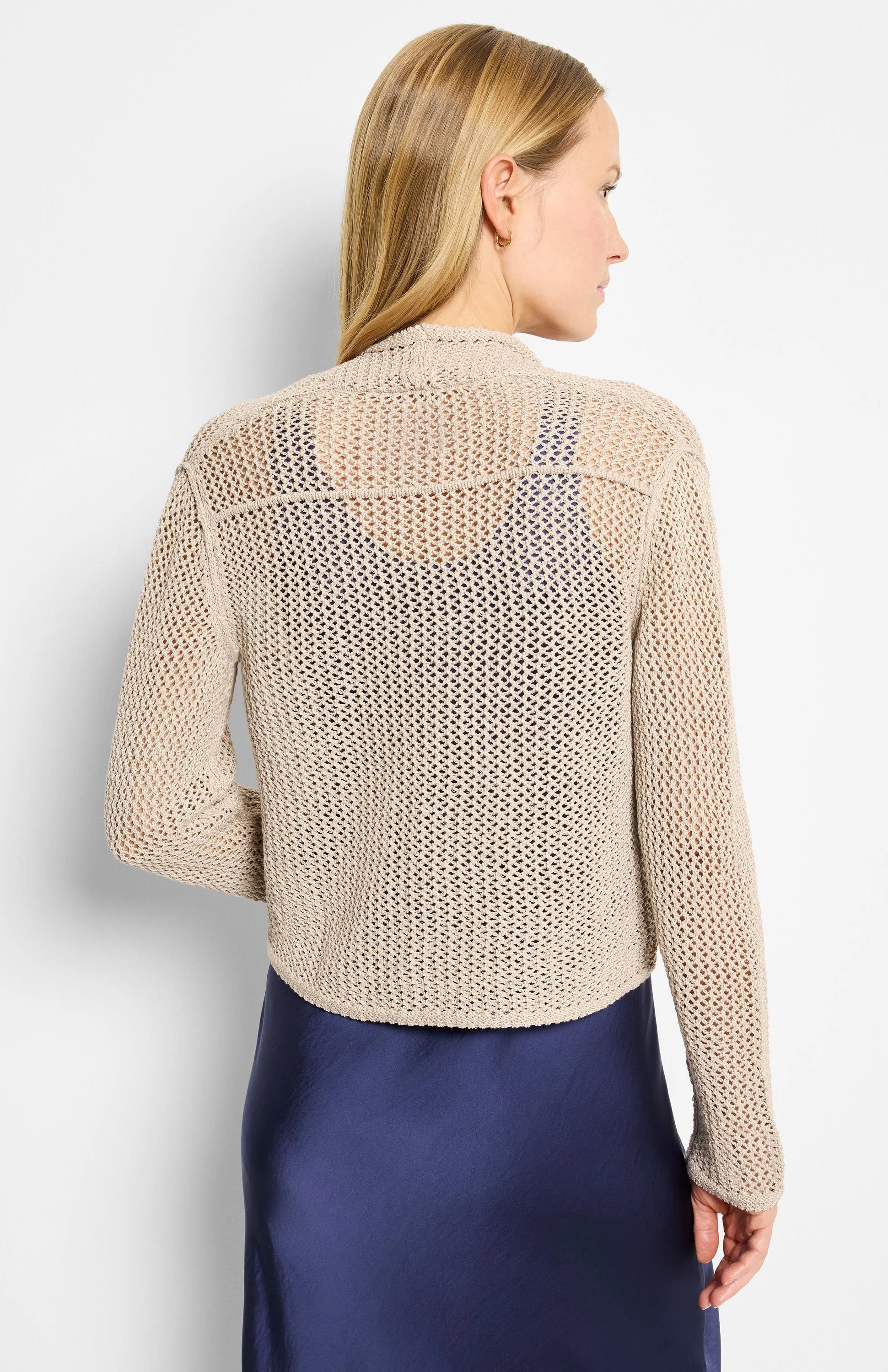 Beige open-knit mesh cocoon cardigan, cropped. Back view on model, showing dark blue underlayer.