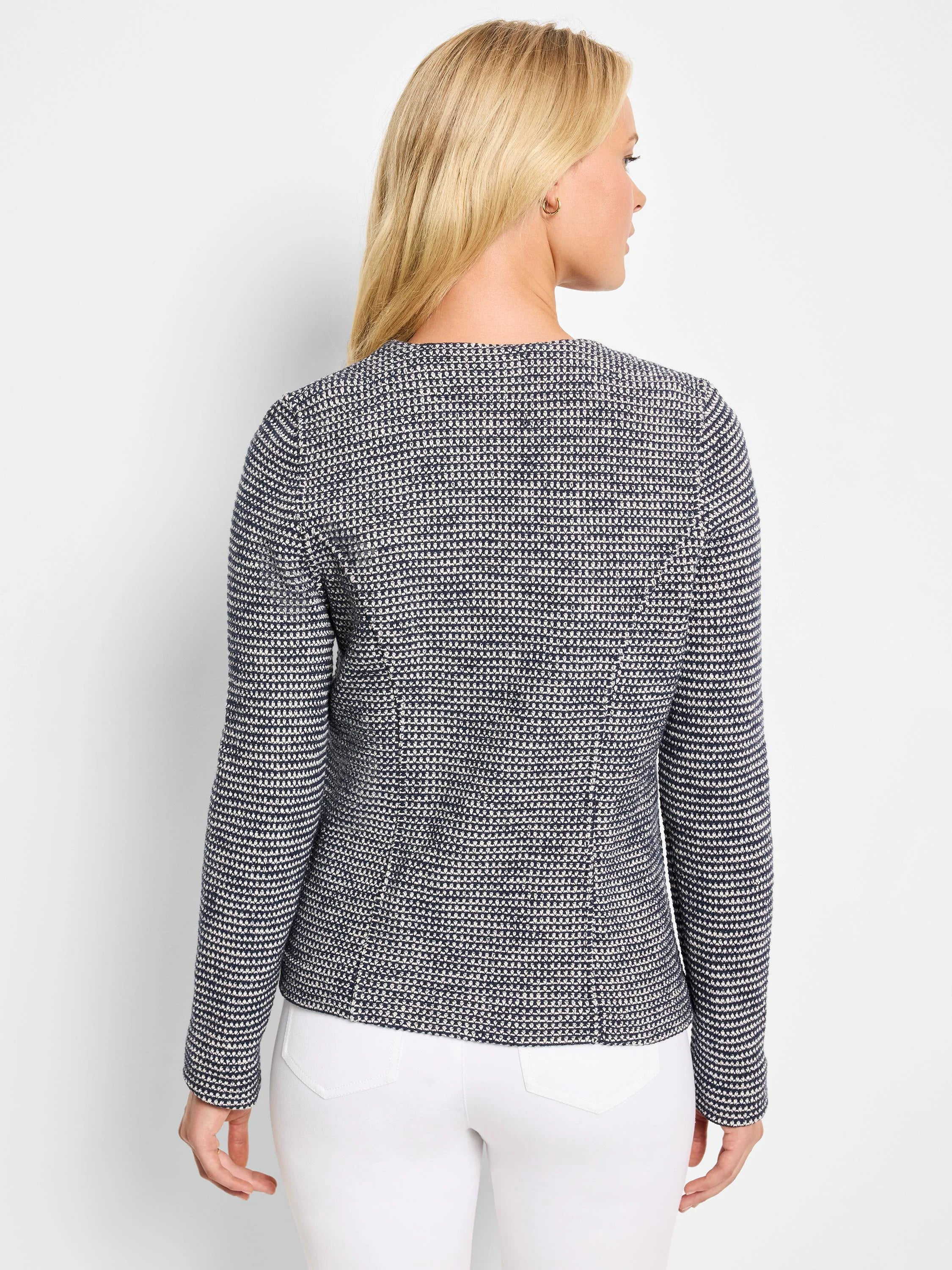 Back of navy blue and white knit jacket with a fine, textured geometric weave.