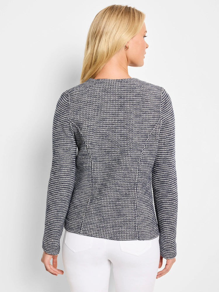 Back of navy blue and white knit jacket with a fine, textured geometric weave.