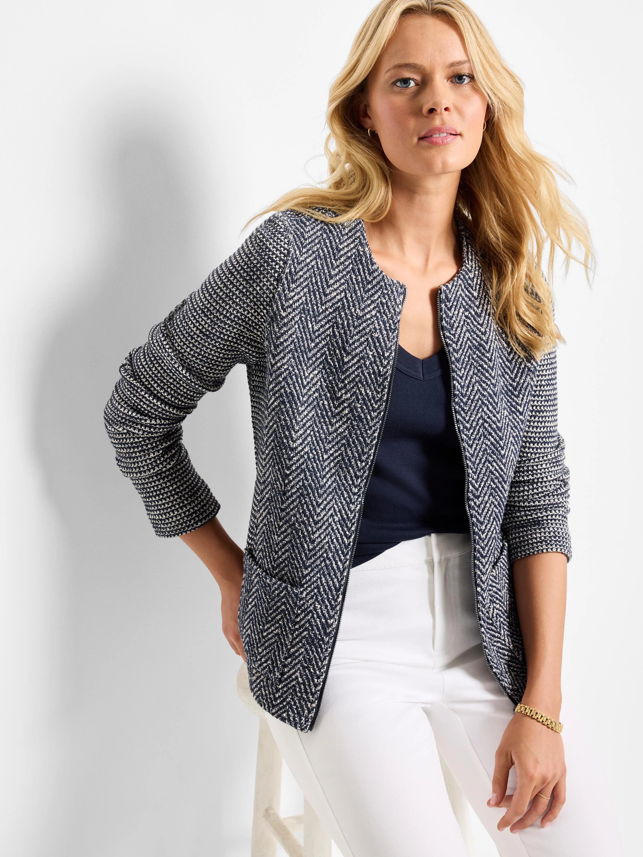 Navy and off-white mixed-weave knit jacket. Features herringbone pattern on body, collarless neckline, zipper front, and...