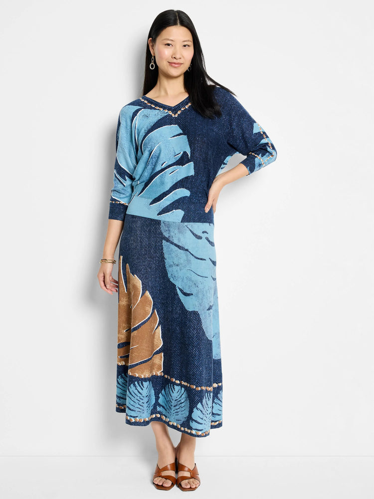 Blue and brown leaf print midi knit skirt. Darker blue background. Hem features a beaded detail.