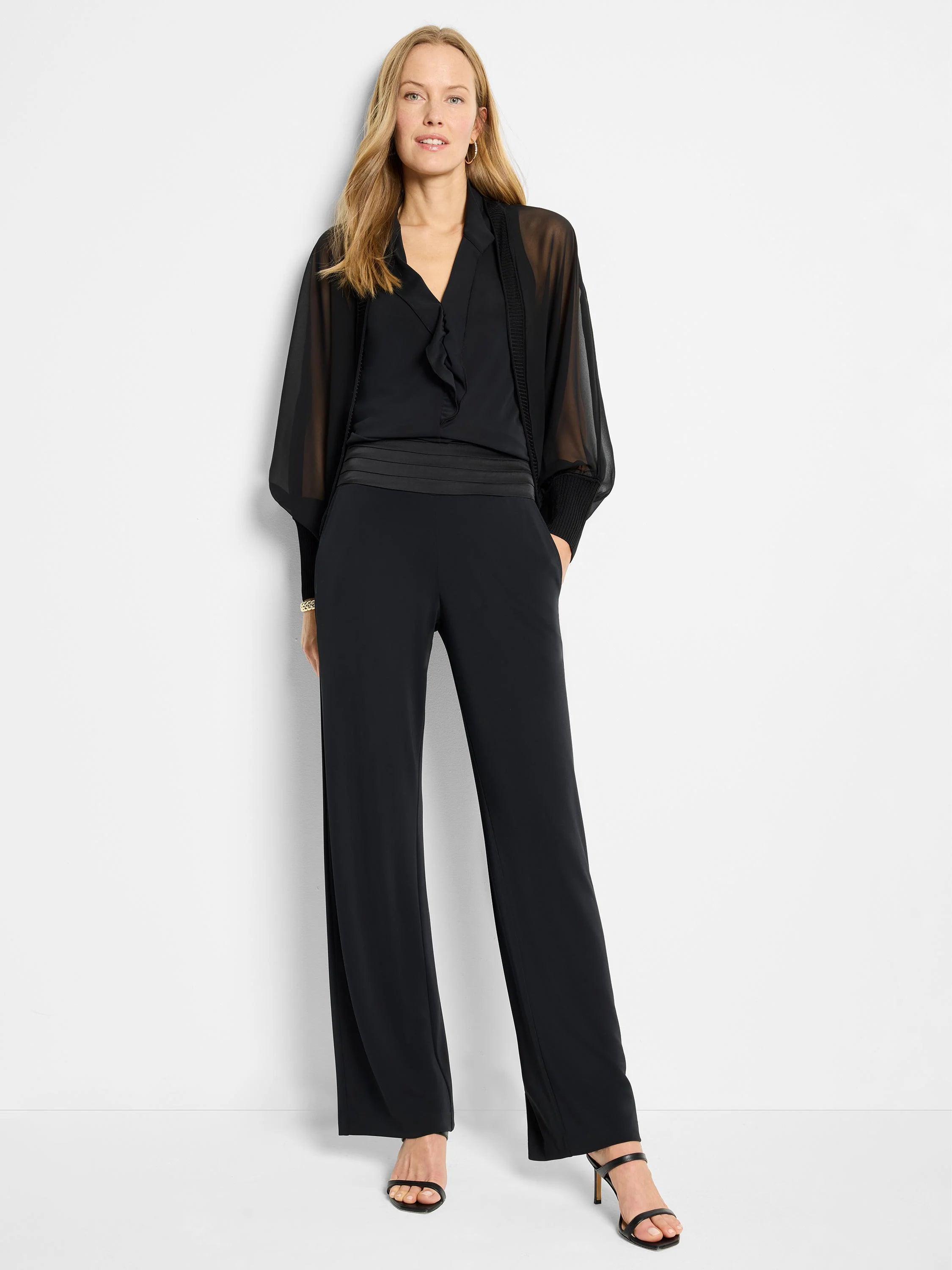 Black wide-leg pants with a black knit crepe cummerbund. Model is wearing a sheer black top.