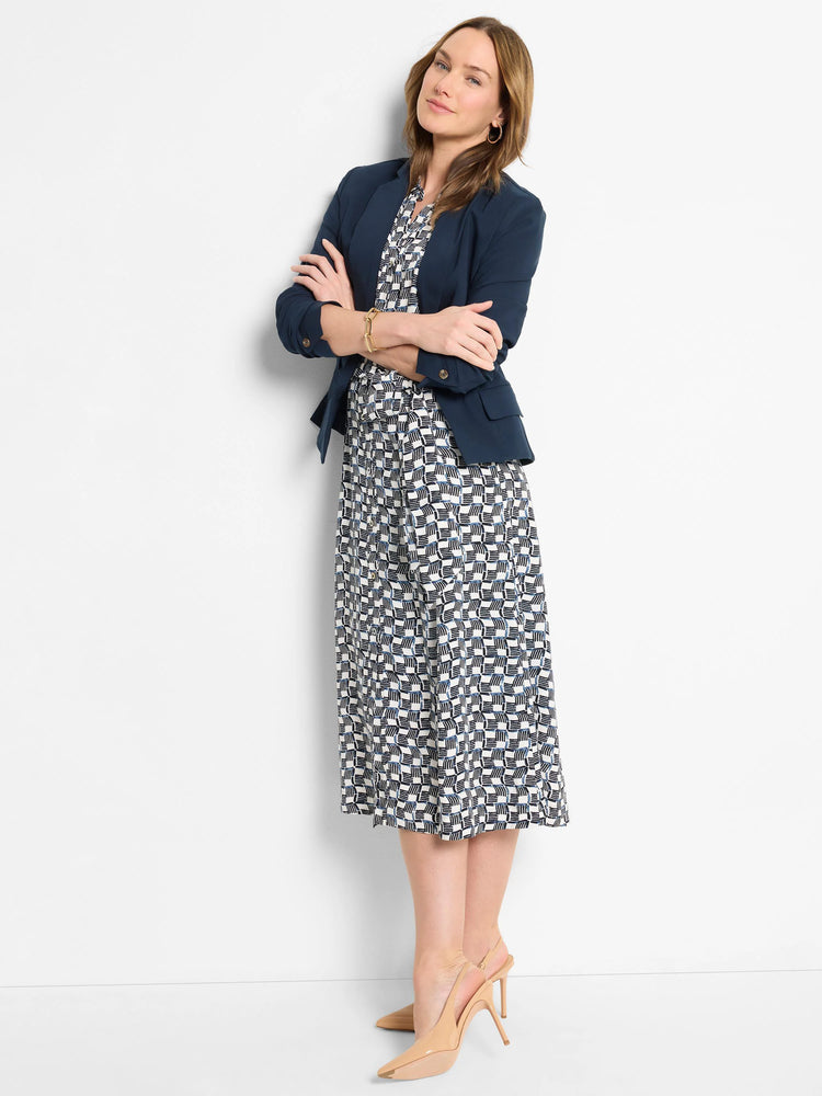 Navy blazer, white & navy geometric-print midi dress. Beige heels.