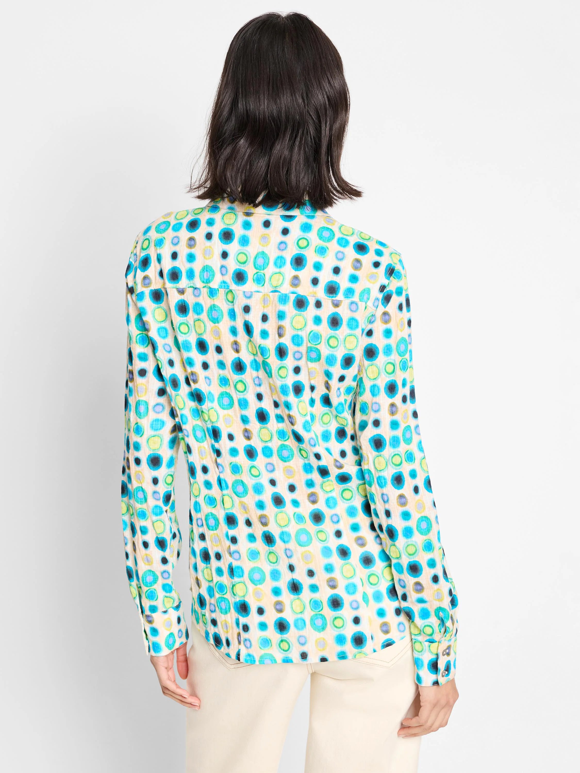Long-sleeve shirt; off-white background with teal, blue, green, and yellow circles.