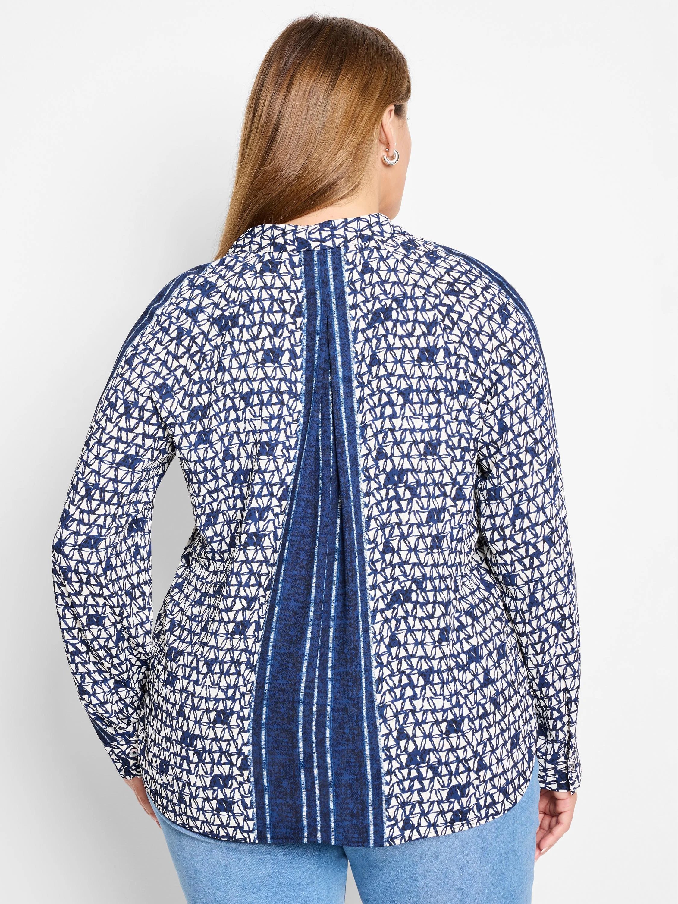White shirt with navy blue geometric pattern and vertical stripes down the back. Long sleeves.