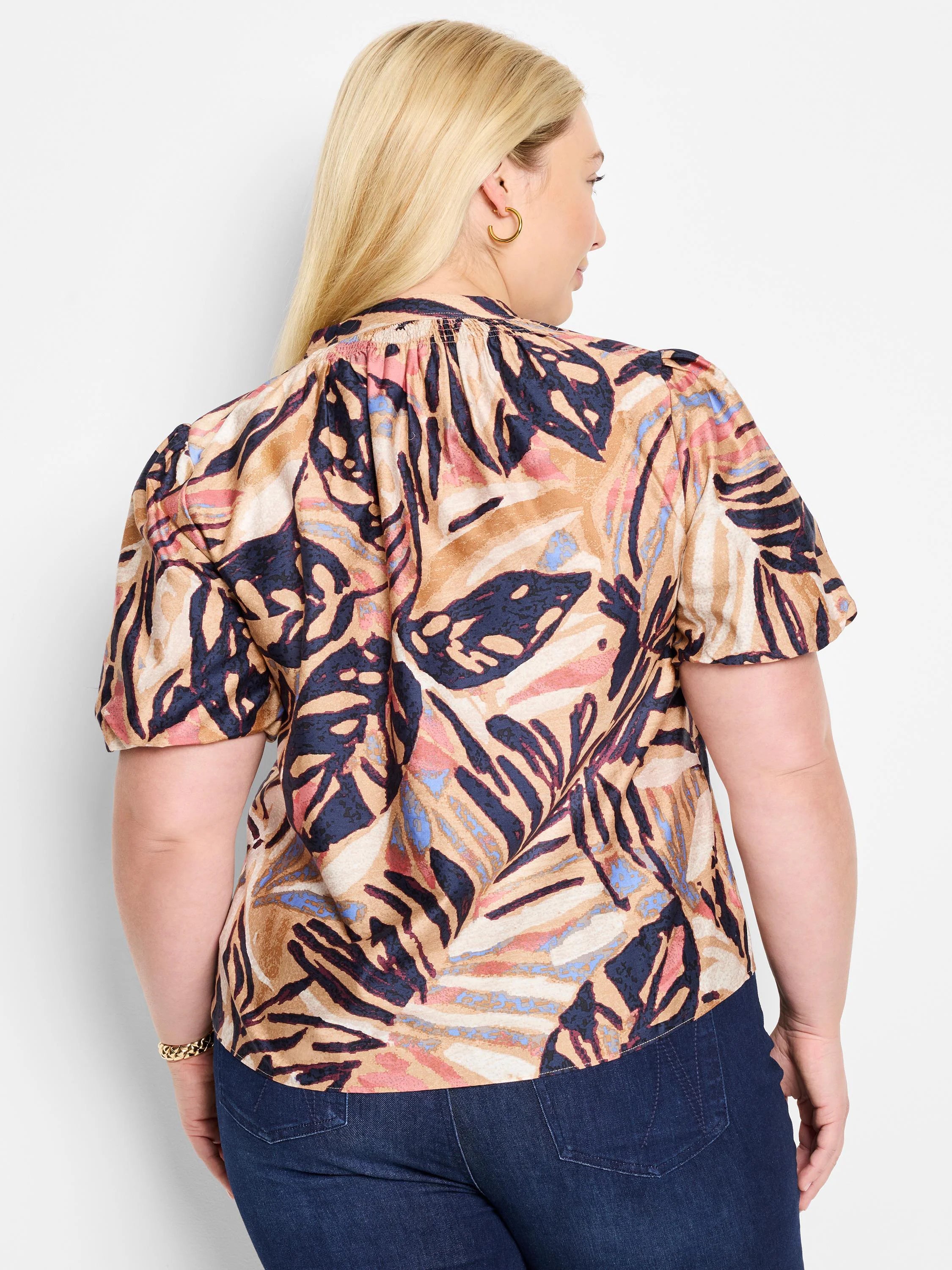 Terracotta top with short sleeves, abstract leaf print in beige,  dark-blue, pink, and light-blue.  V-neck.