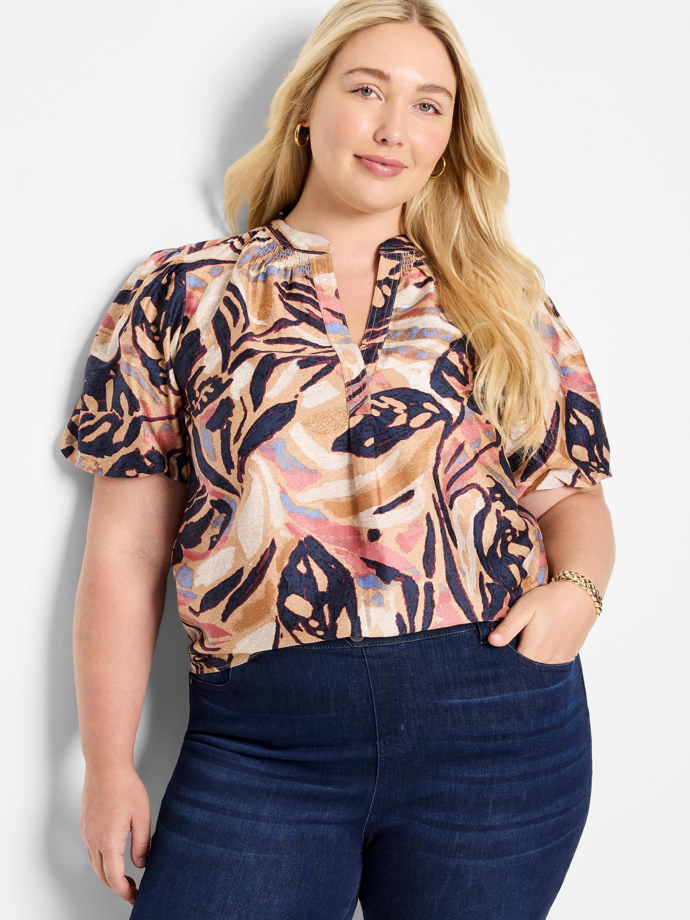 Terracotta top with abstract print in beige, dark-blue, and muted pink. Short sleeves, V-neck.