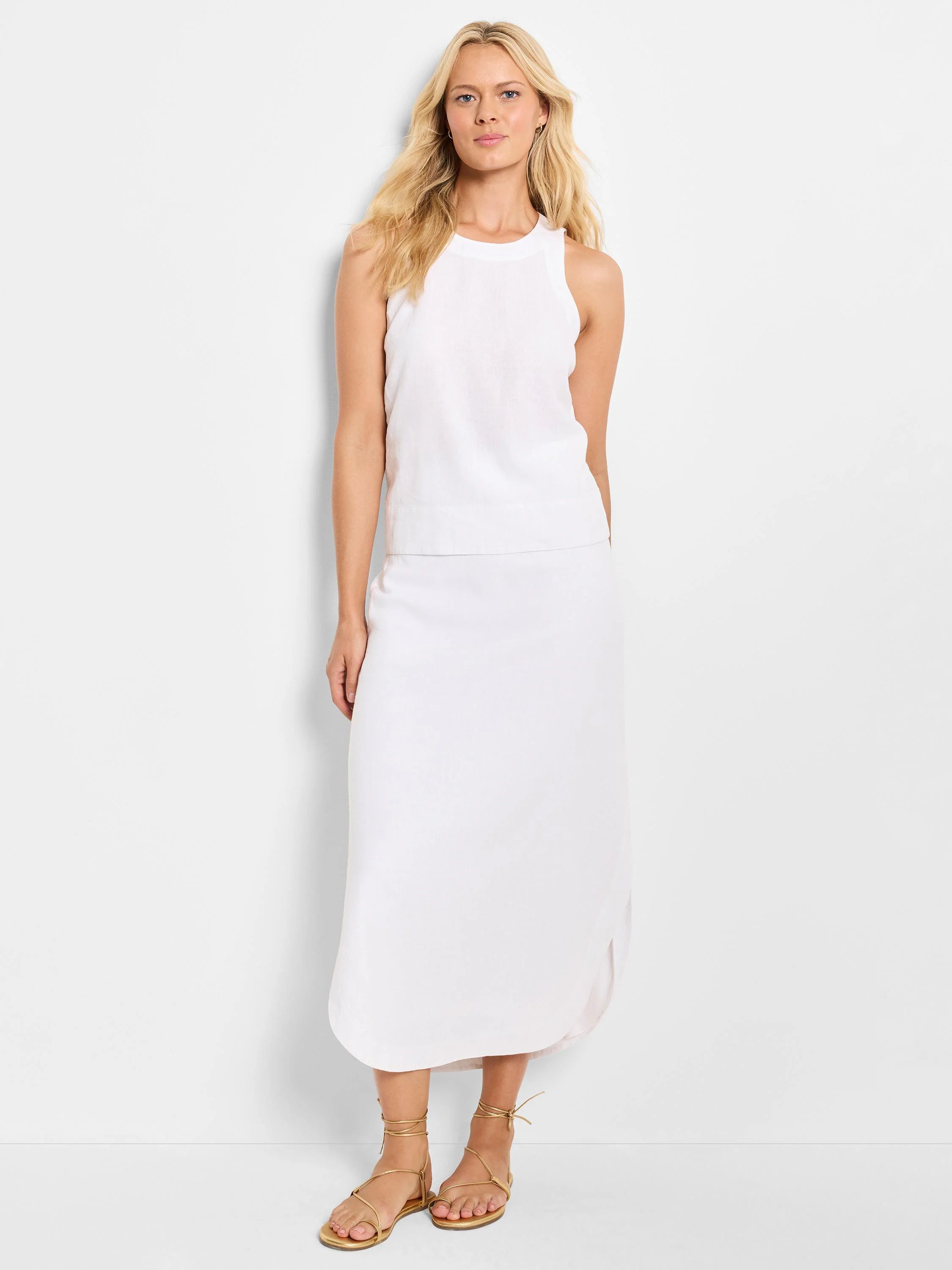 White linen sleeveless top and midi skirt. The skirt has a slight curve at the hem.