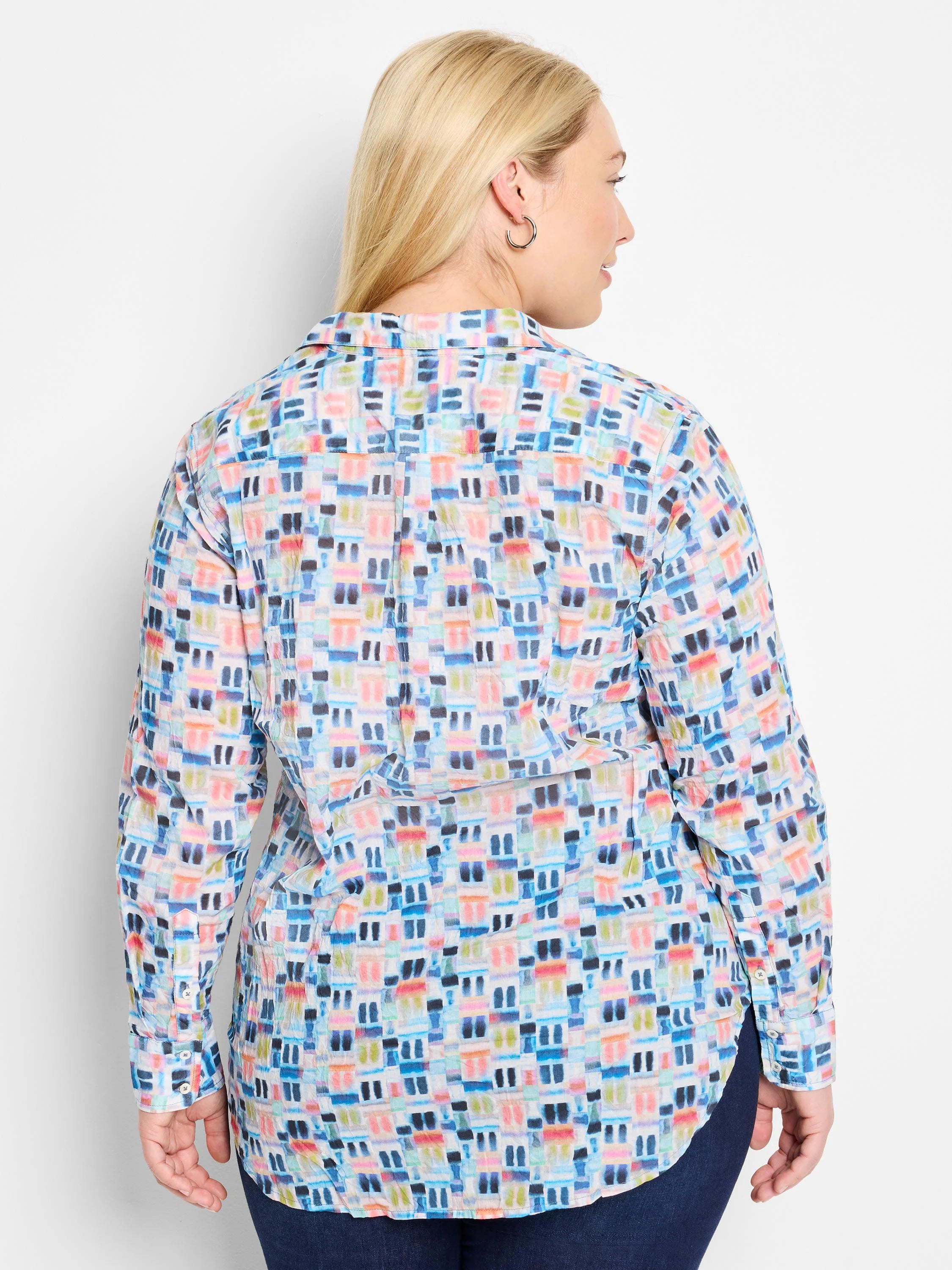 Long-sleeve cotton shirt; pale background with an all-over watercolor print in blues, pinks, and greens. Buttoned cuffs.
