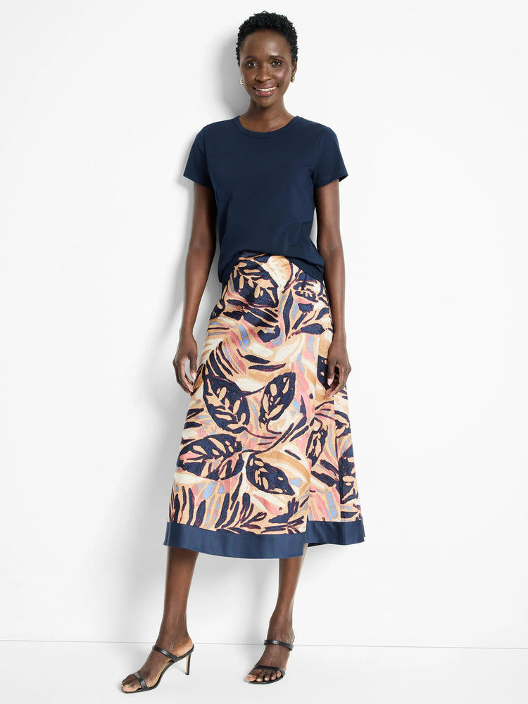 Terracotta midi skirt with a navy blue band at the hem. Features a leaf print in terracotta, navy, blush pink, and light...