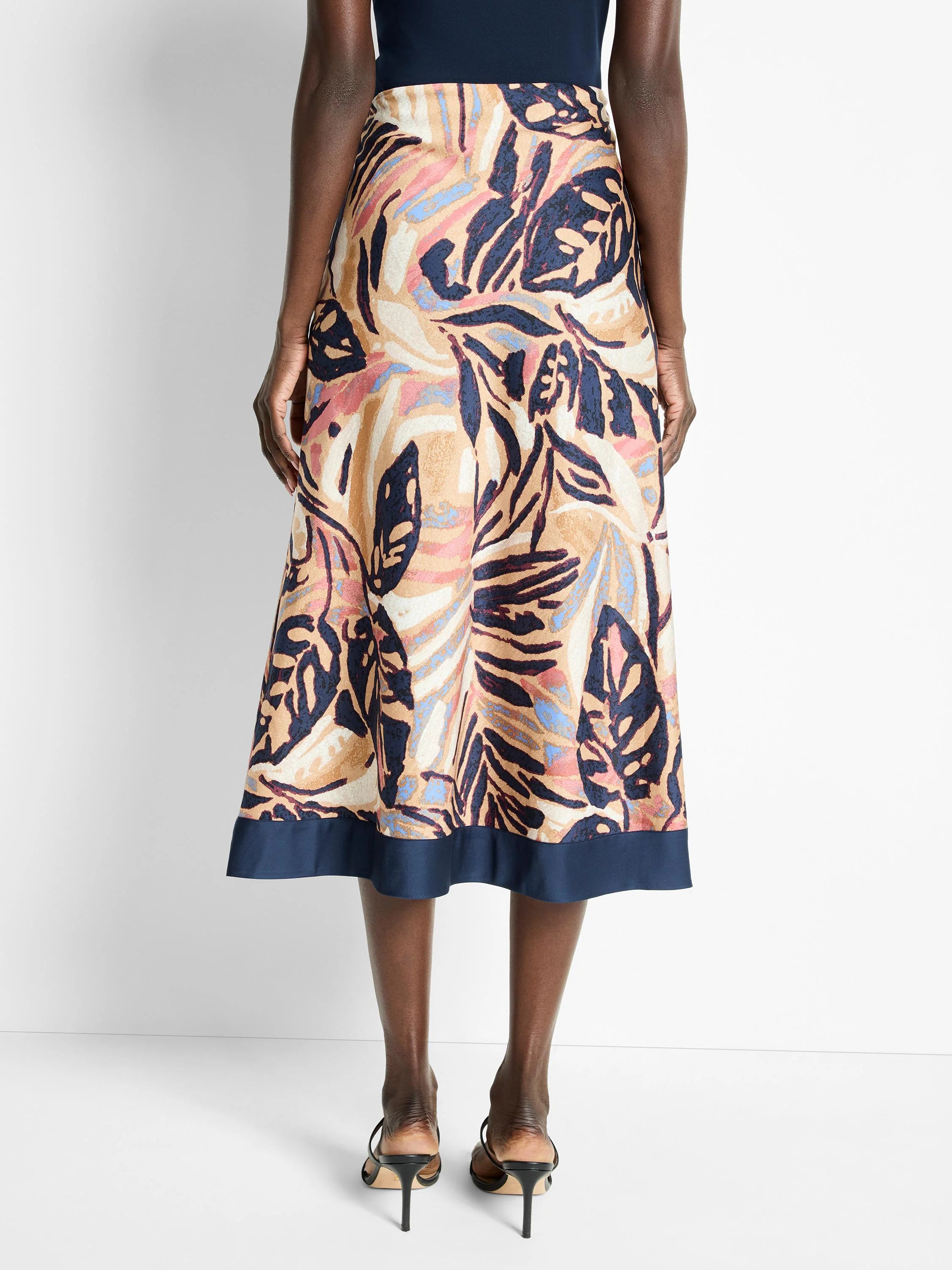 Terracotta midi skirt with abstract leaf print in beige, pink, blue, and navy.  Navy waistband.