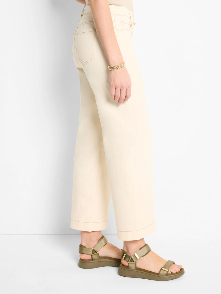 Off-white wide-leg jeans; cuffed hems. Model wears olive green sandals.