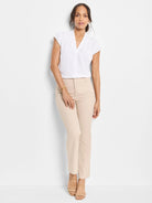 Light beige slim-fit pants with a flat front and straight leg, worn by a model.