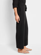 Black linen pants with a drawstring waist and small tassel detail.