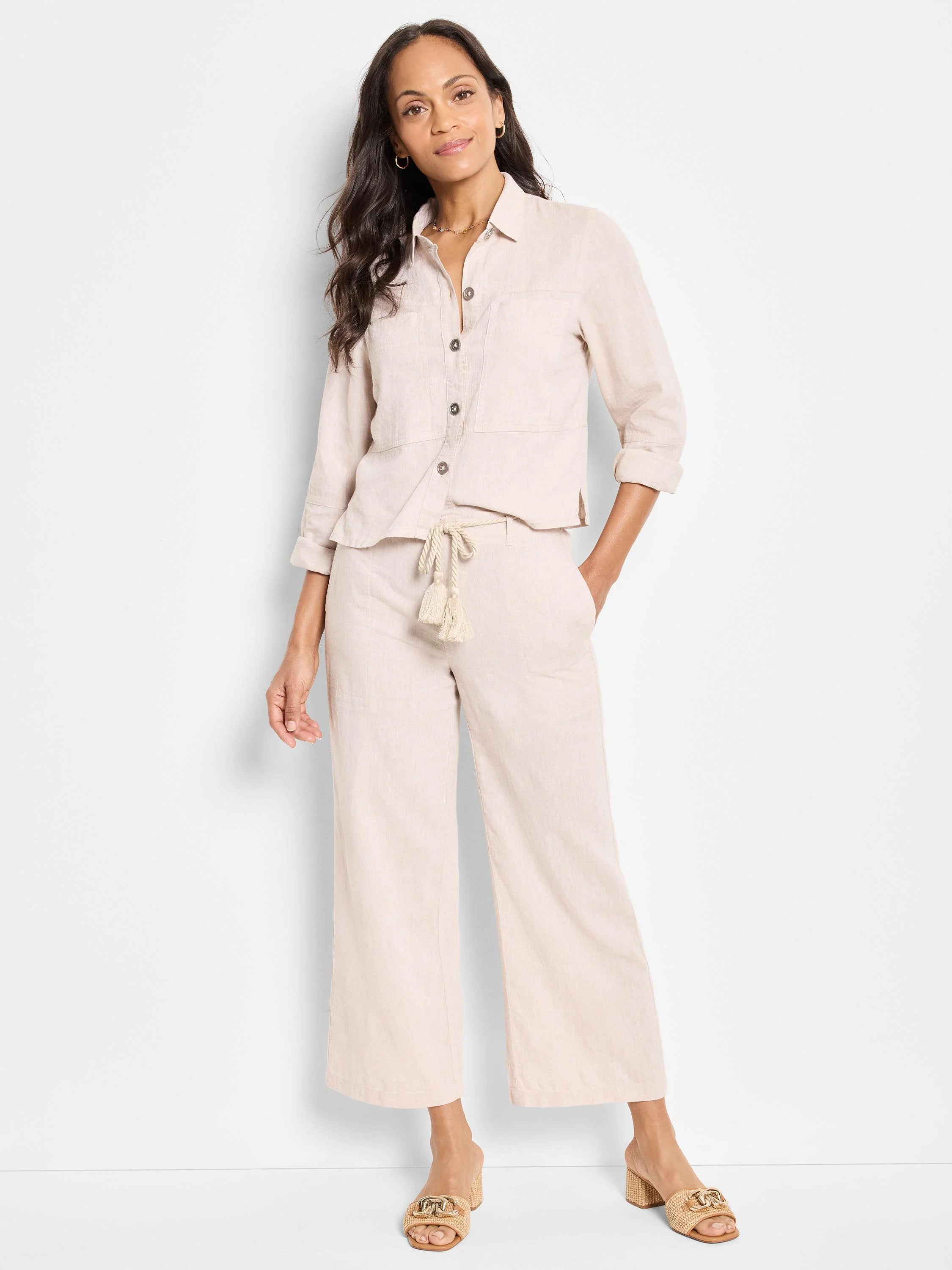 Beige linen wide-leg pants with a beige rope belt and tassels.