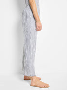 White wide-leg pants with thin, dark blue pinstripes; raw hem.