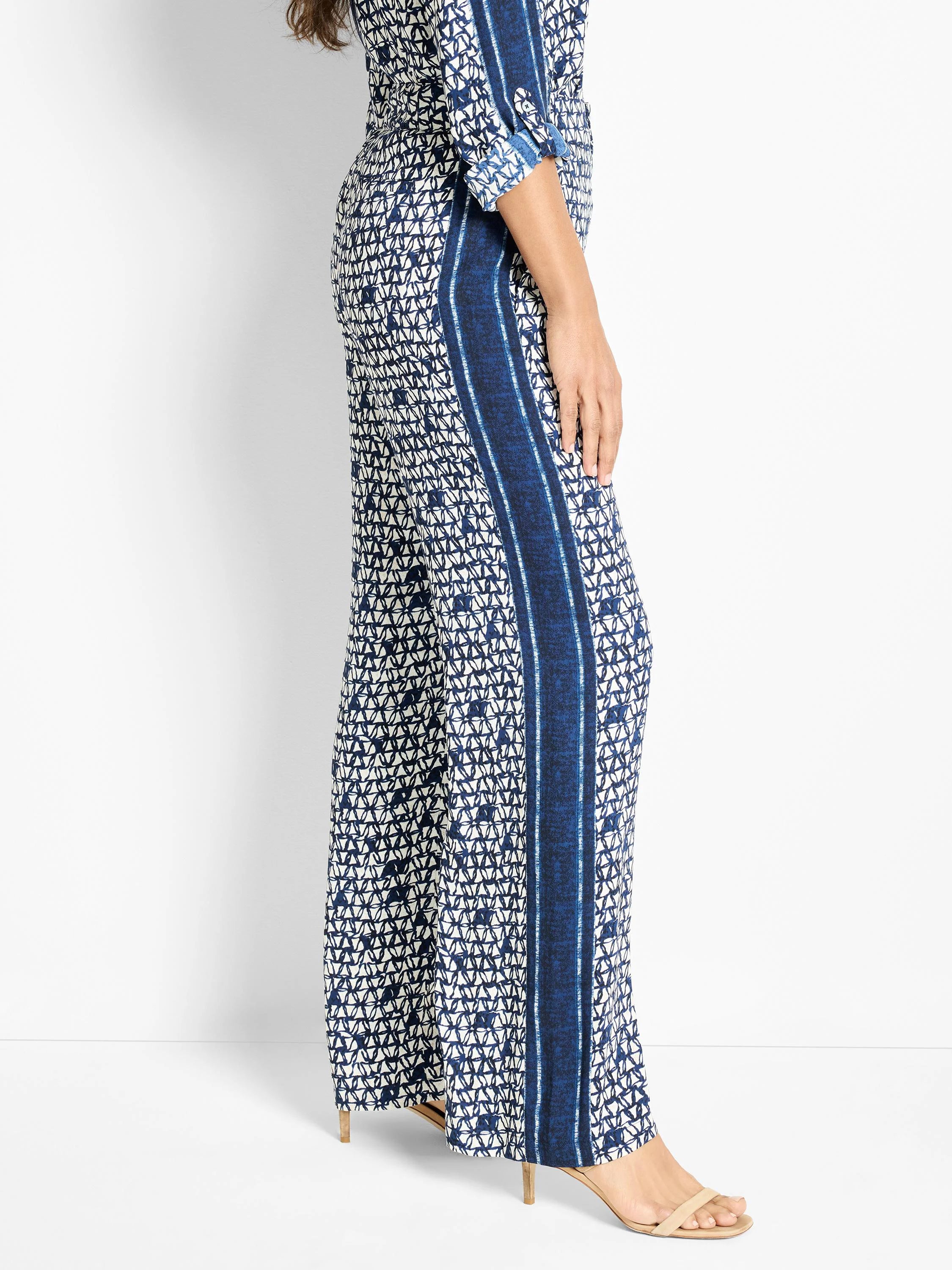 Wide-leg pants; off-white background with navy blue geometric pattern and vertical stripes.