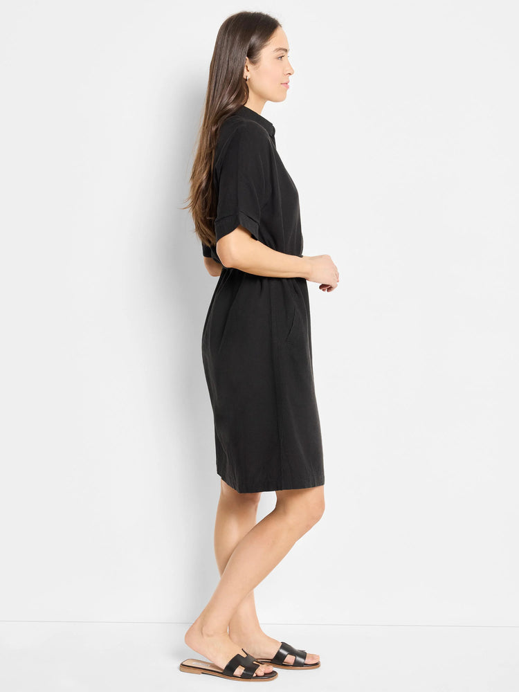 Black belted linen dress, short sleeves, knee-length. Model wears sandals.