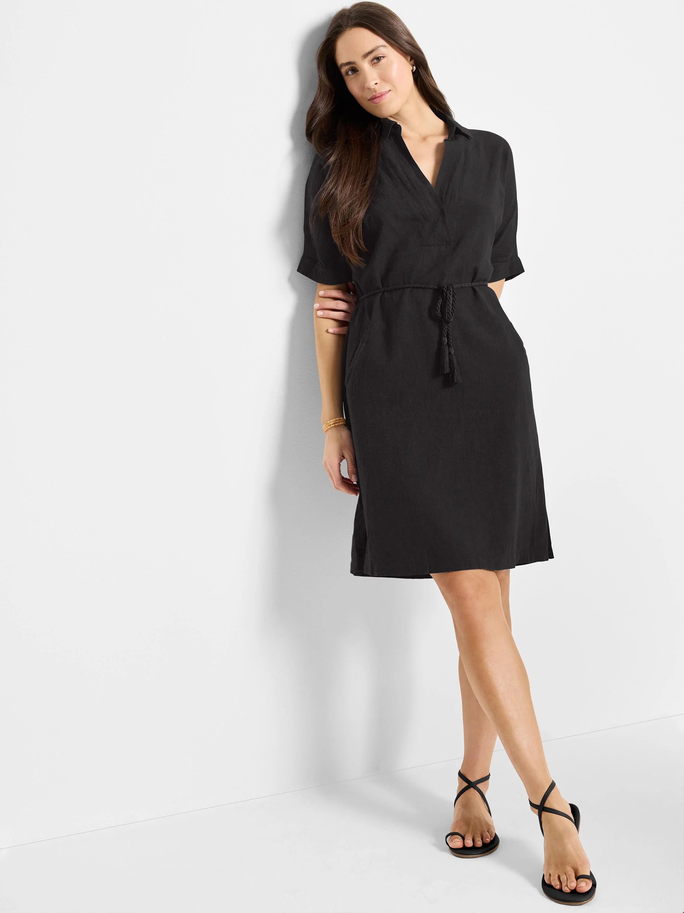 Black belted linen dress, short sleeves, knee-length, V-neck.  Belted waist with tassels.