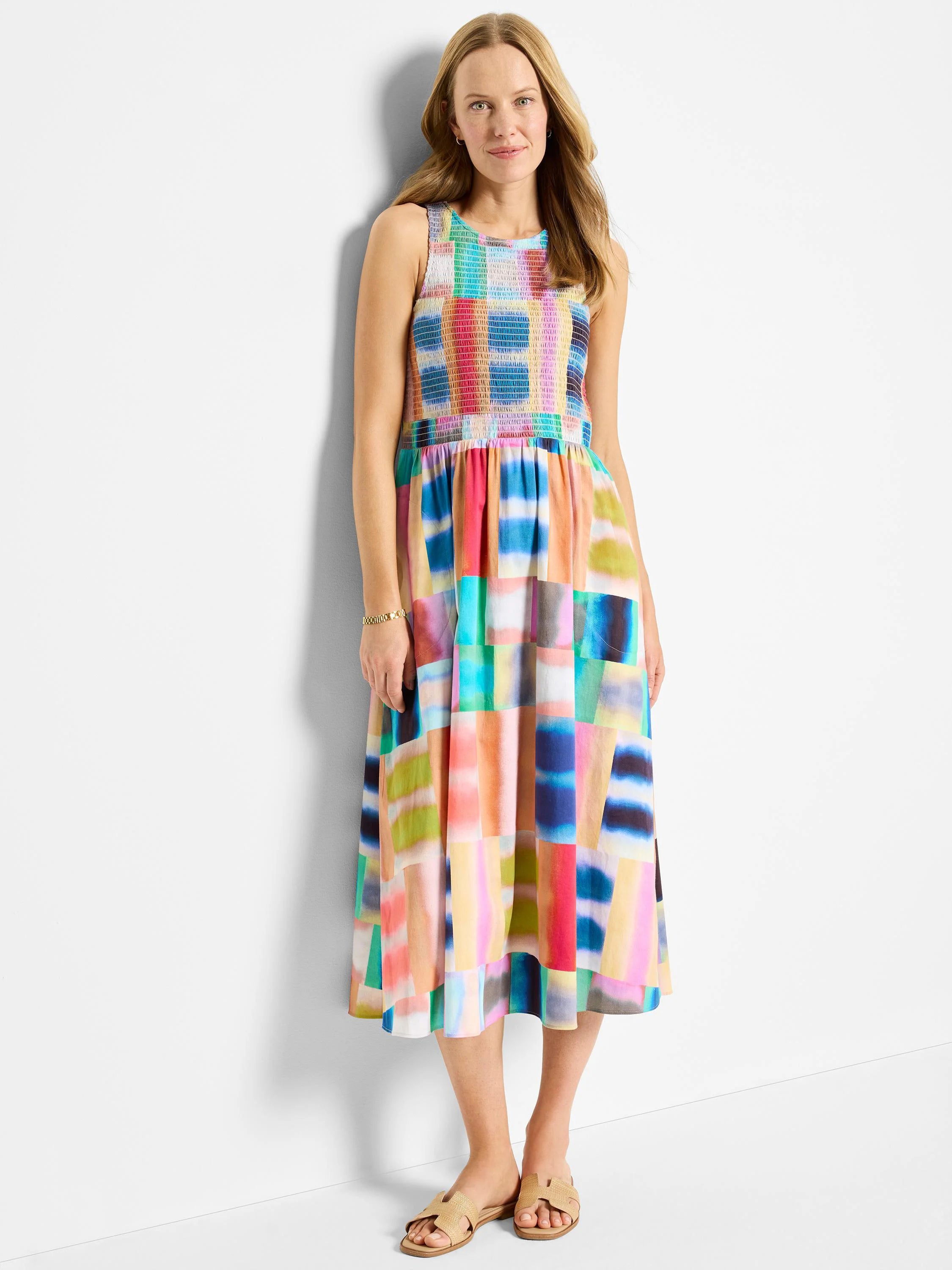Midi sleeveless dress with multicolored abstract block print. Colors include pink, teal, orange, and blue. Smocked bodice.