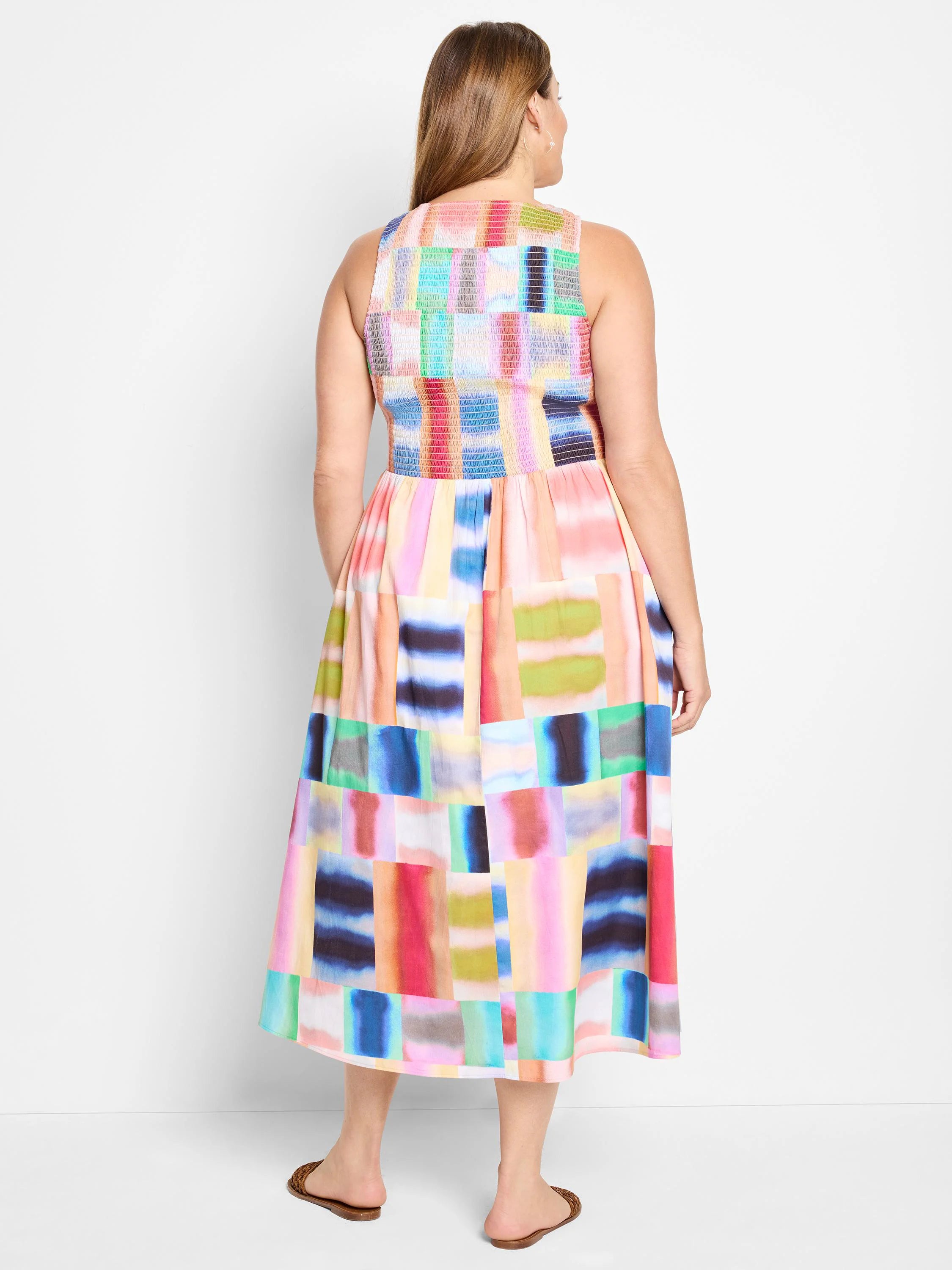 Sleeveless midi dress, multicolored abstract print of pink, blue, green, and red blocks on white background. Back view.