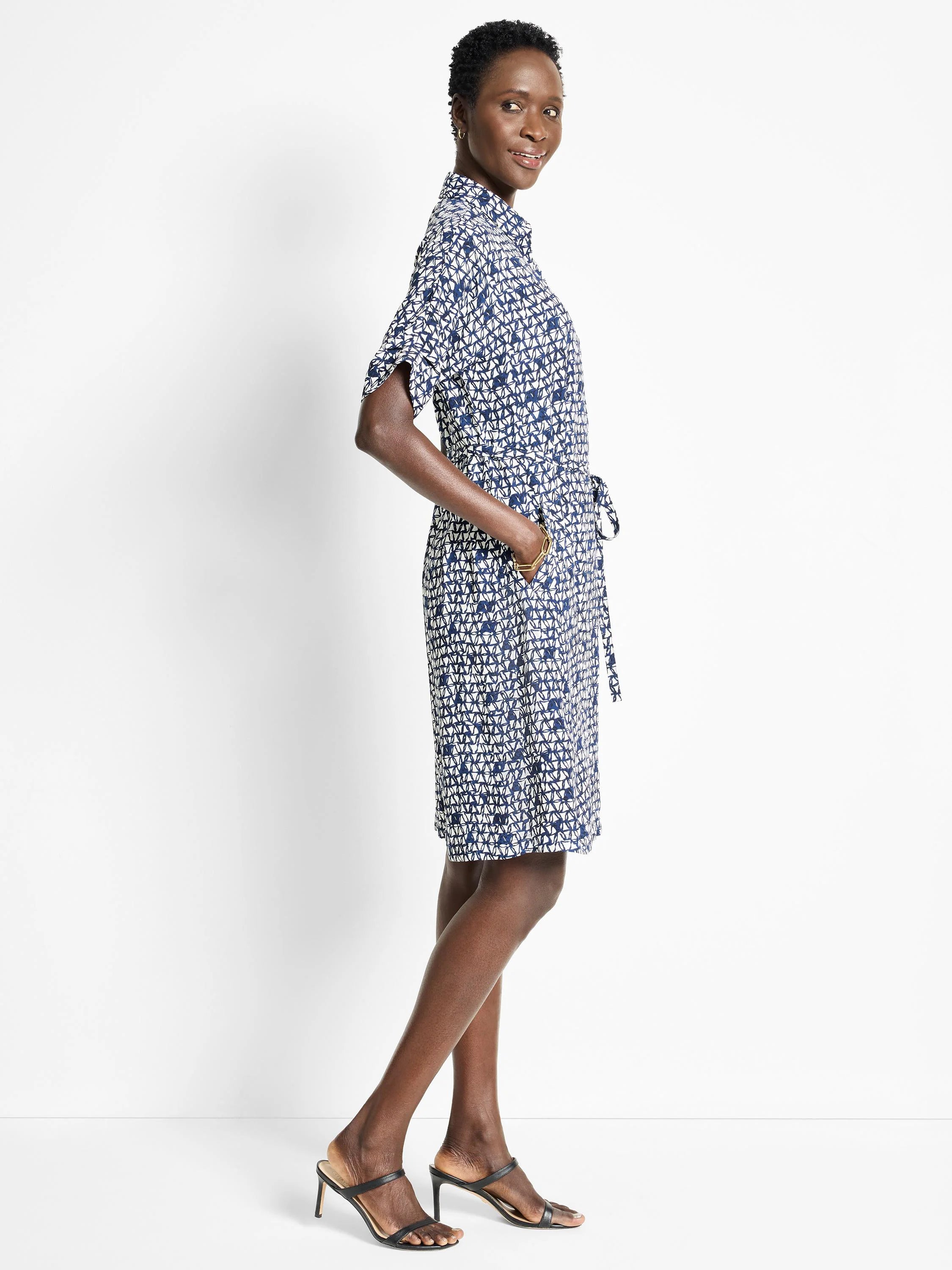 Navy blue midi dress with a white geometric print, short sleeves, and a self-tie belt.