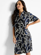 Black shirt dress with navy and off-white abstract leaf print. Short sleeves, collared neckline.