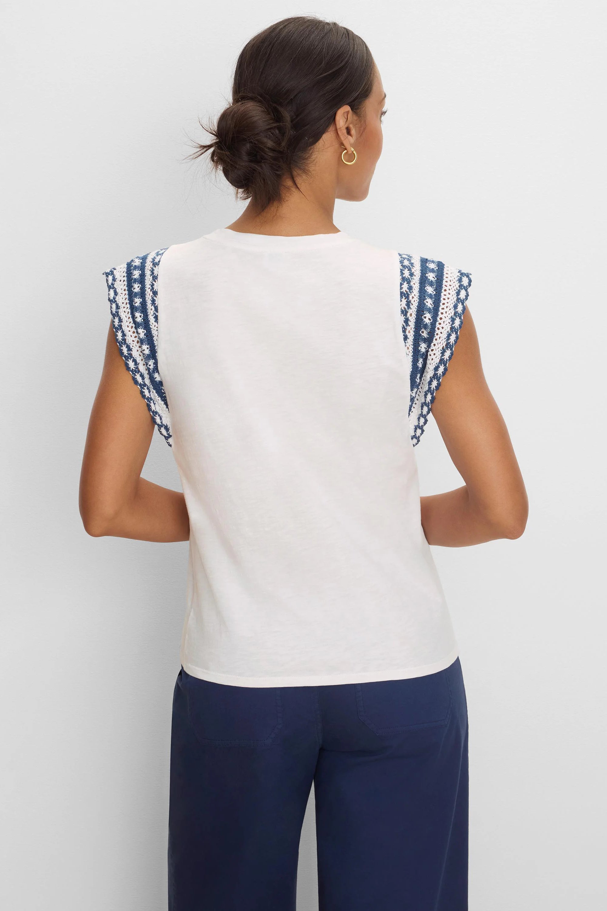 Off-white cotton slub top, back view. Cap sleeves have navy & white patterned knit trim.