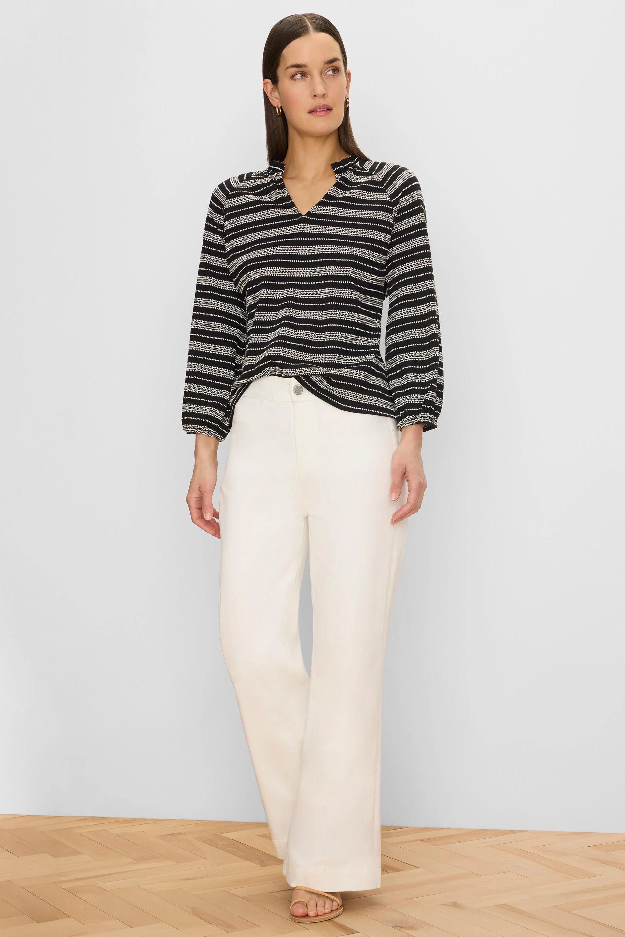 Black knit top with white horizontal dotted stripes, V-neck with ruffled collar, and 3/4 elastic cuff sleeves.
