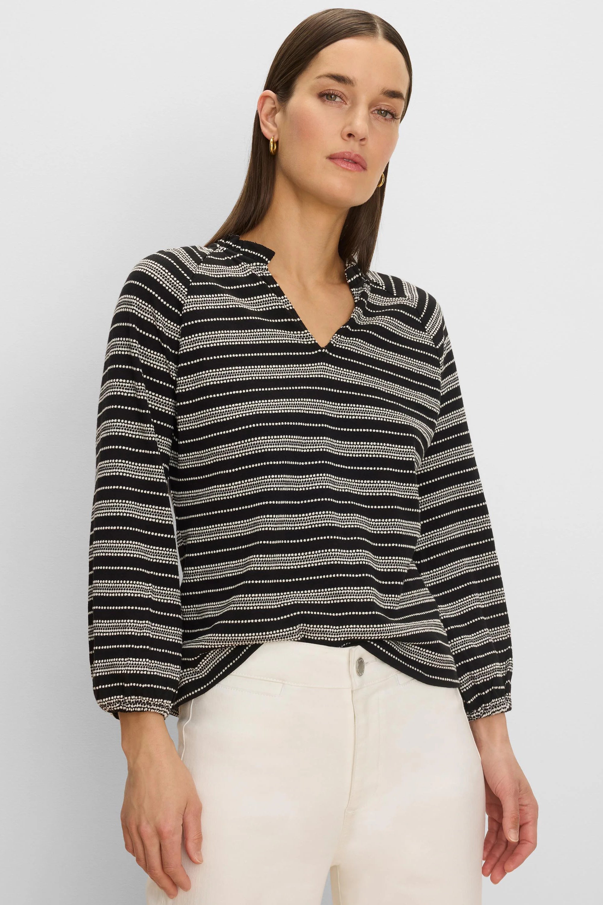 Black knit top with off-white dotted horizontal stripes, V-neck, gathered collar, and elastic cuffs.