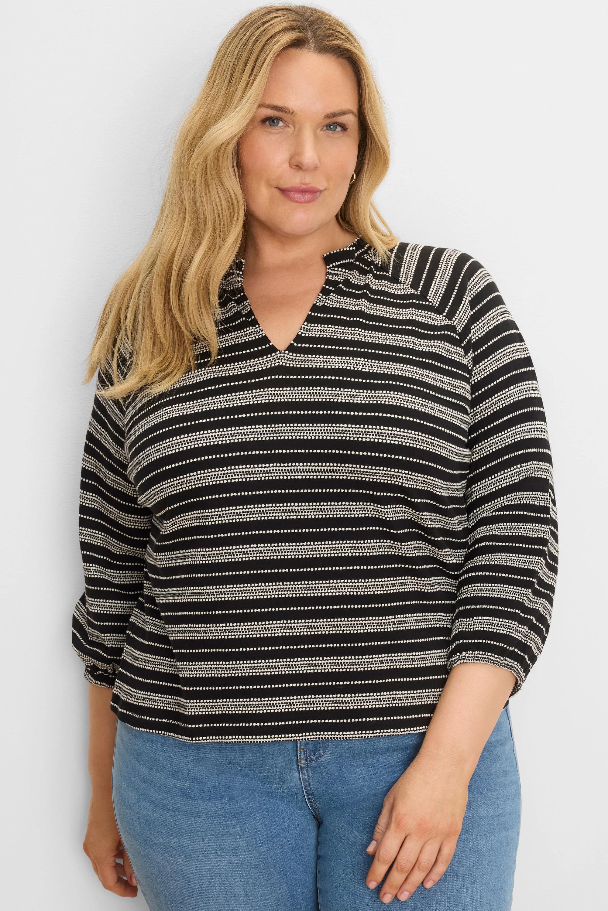 Black and white knit top with mixed horizontal stripes (solid & dotted), a split V-neck, and 3/4 sleeves.
