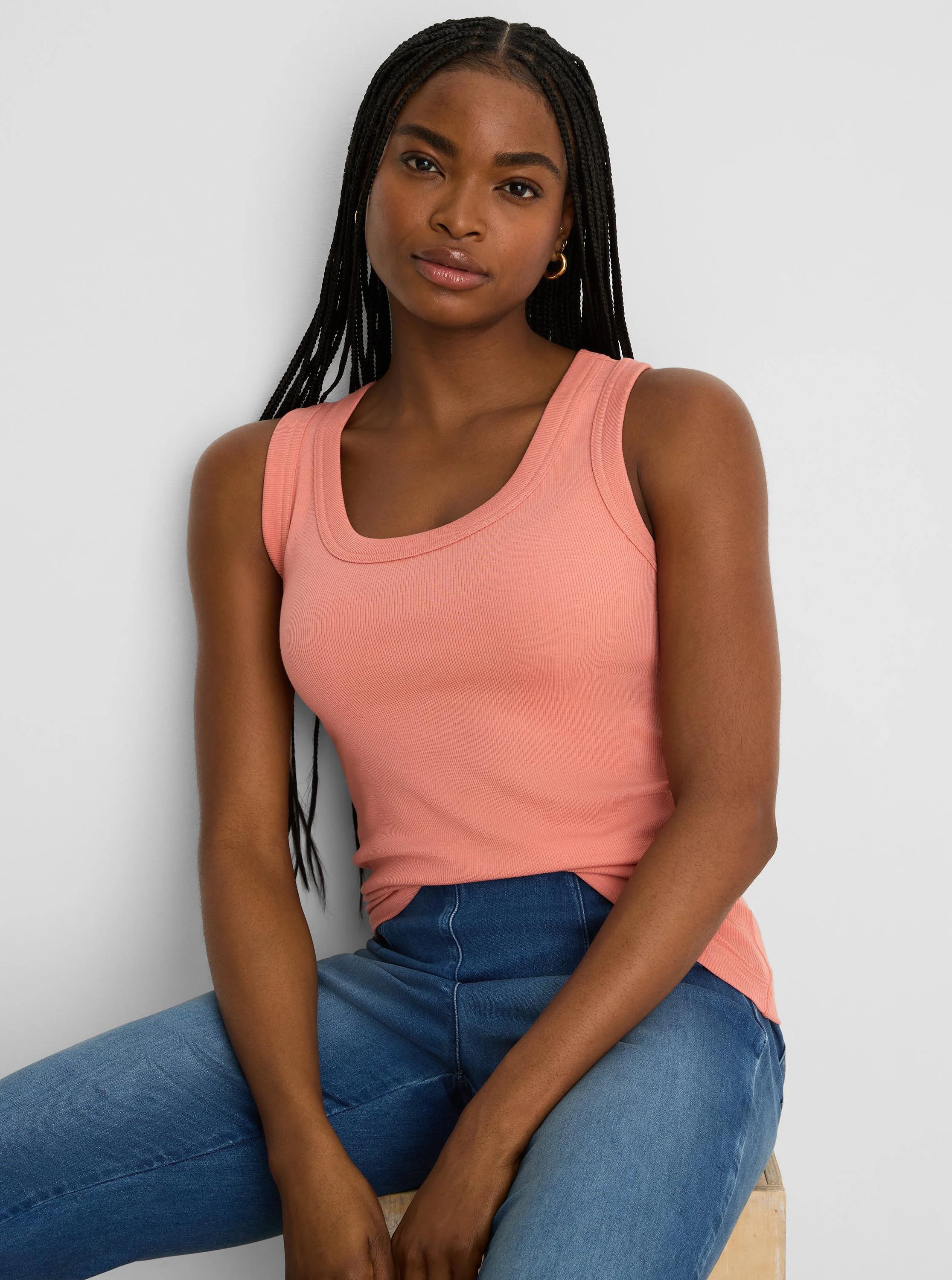 Peach ribbed scoop neck tank on a model, featuring a wide scoop neckline and close fit.