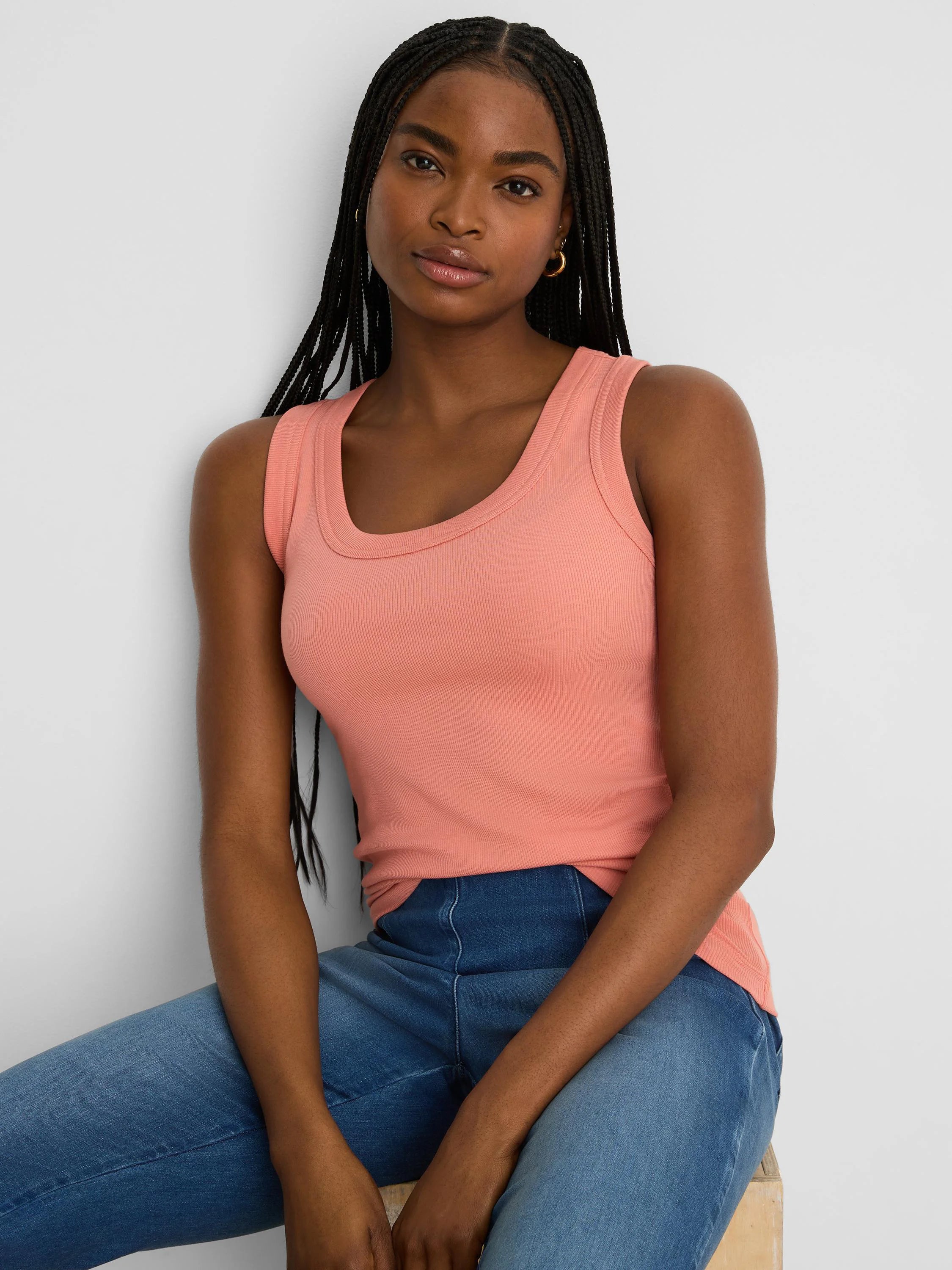 Peach ribbed scoop neck tank on a model, featuring a wide scoop neckline and close fit.