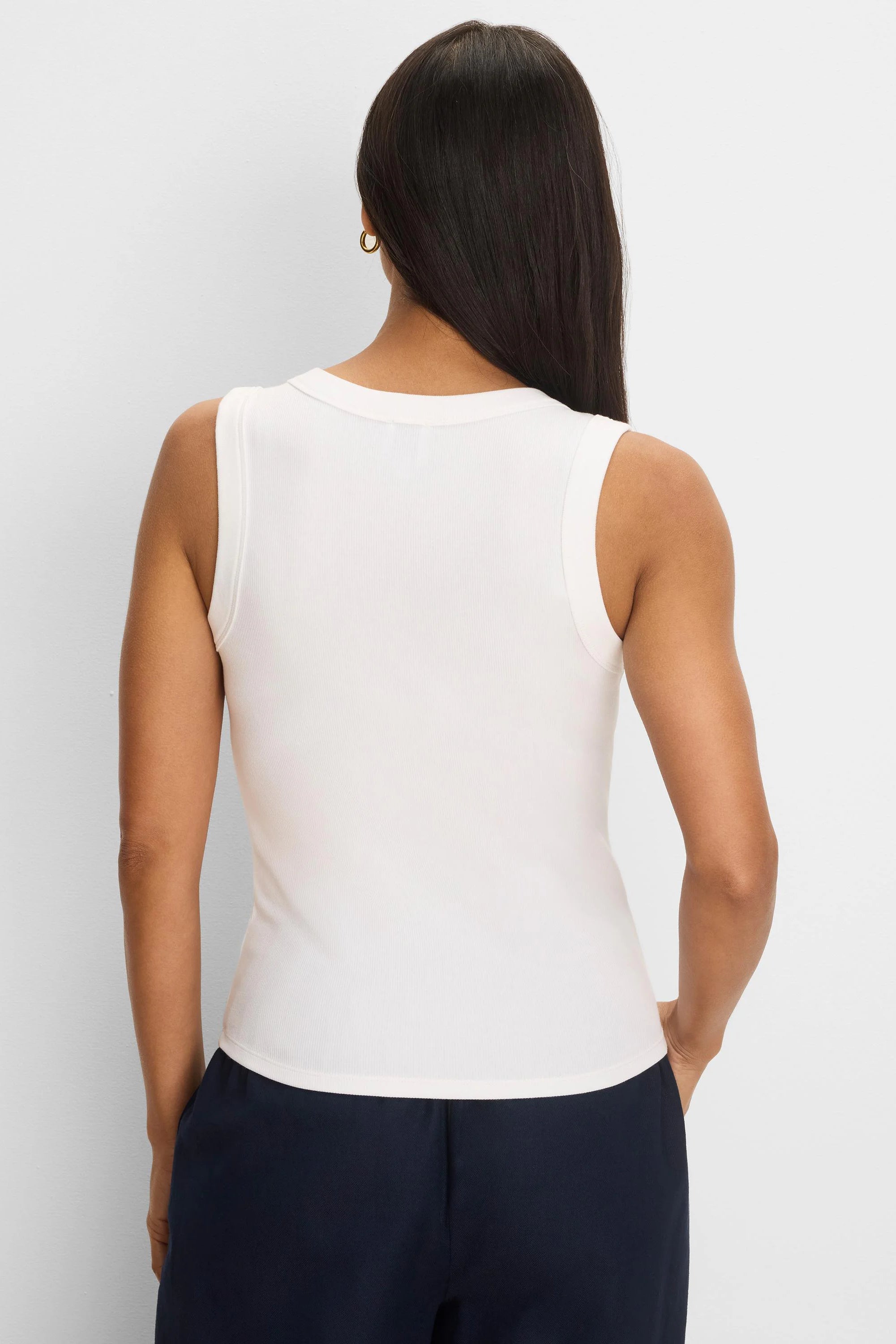 Cream rib-knit tank top, sleeveless, seen from the back on a model.