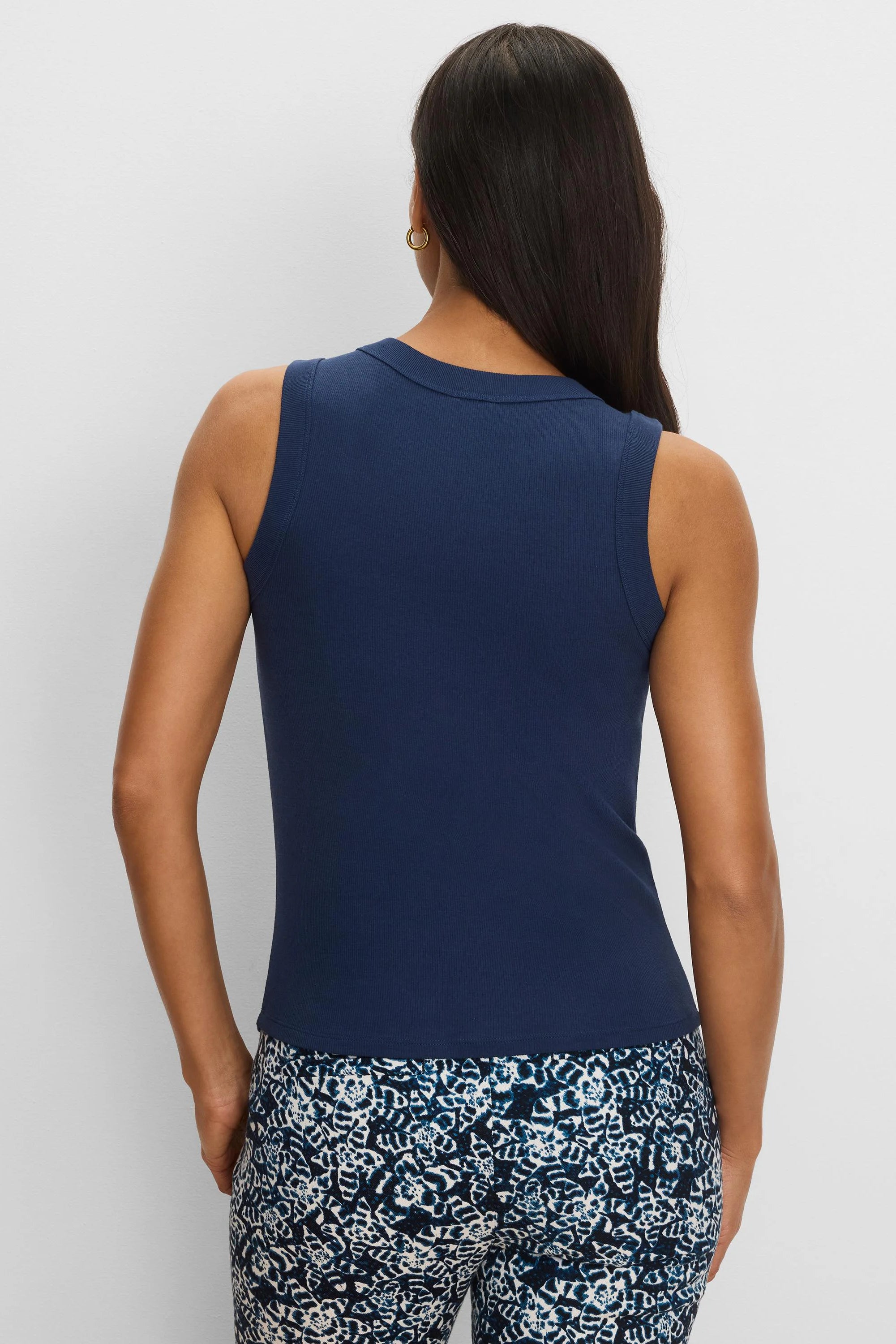 Navy blue ribbed knit tank top, shown from the back on a model. Close-fitting. No studs visible.