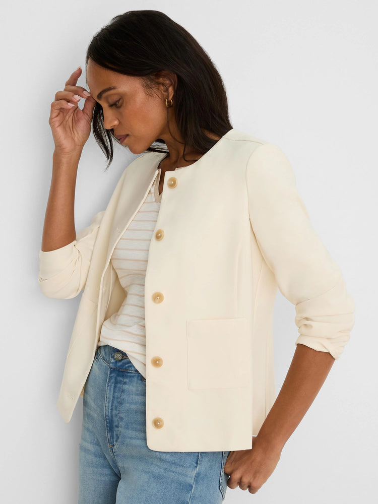 Ivory collarless jacket with tan button-front closure and two front patch pockets.