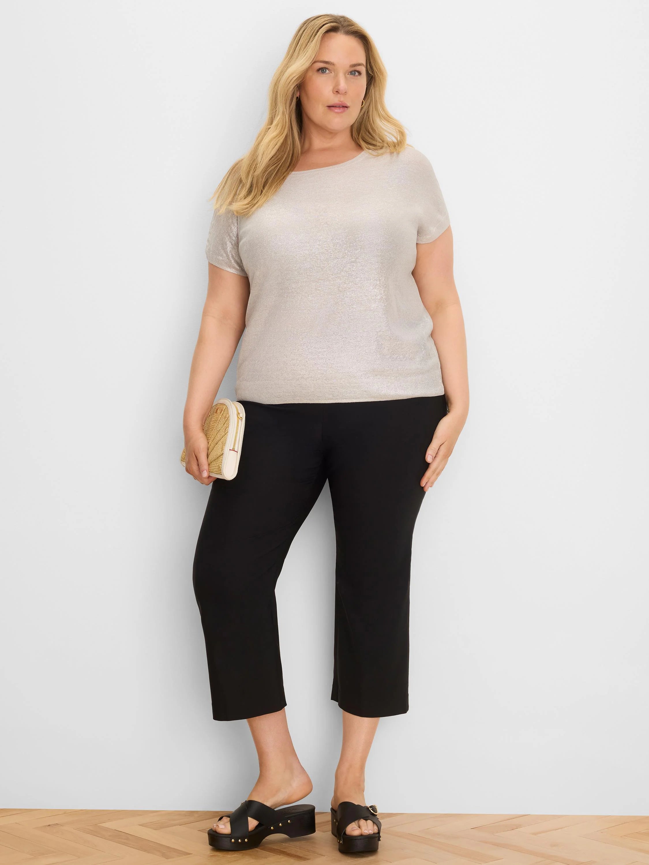 Shimmery light taupe, short-sleeved knit sweater with a wide neckline, modeled on a woman.