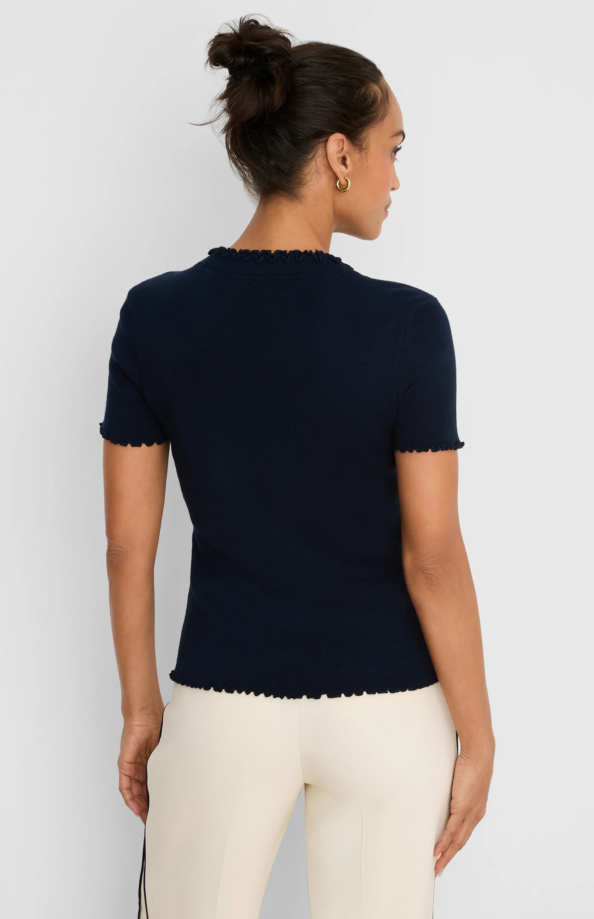 Dark blue ribbed sweater tee with short sleeves and ruffle trim on the neck, sleeve cuffs, and bottom hem.