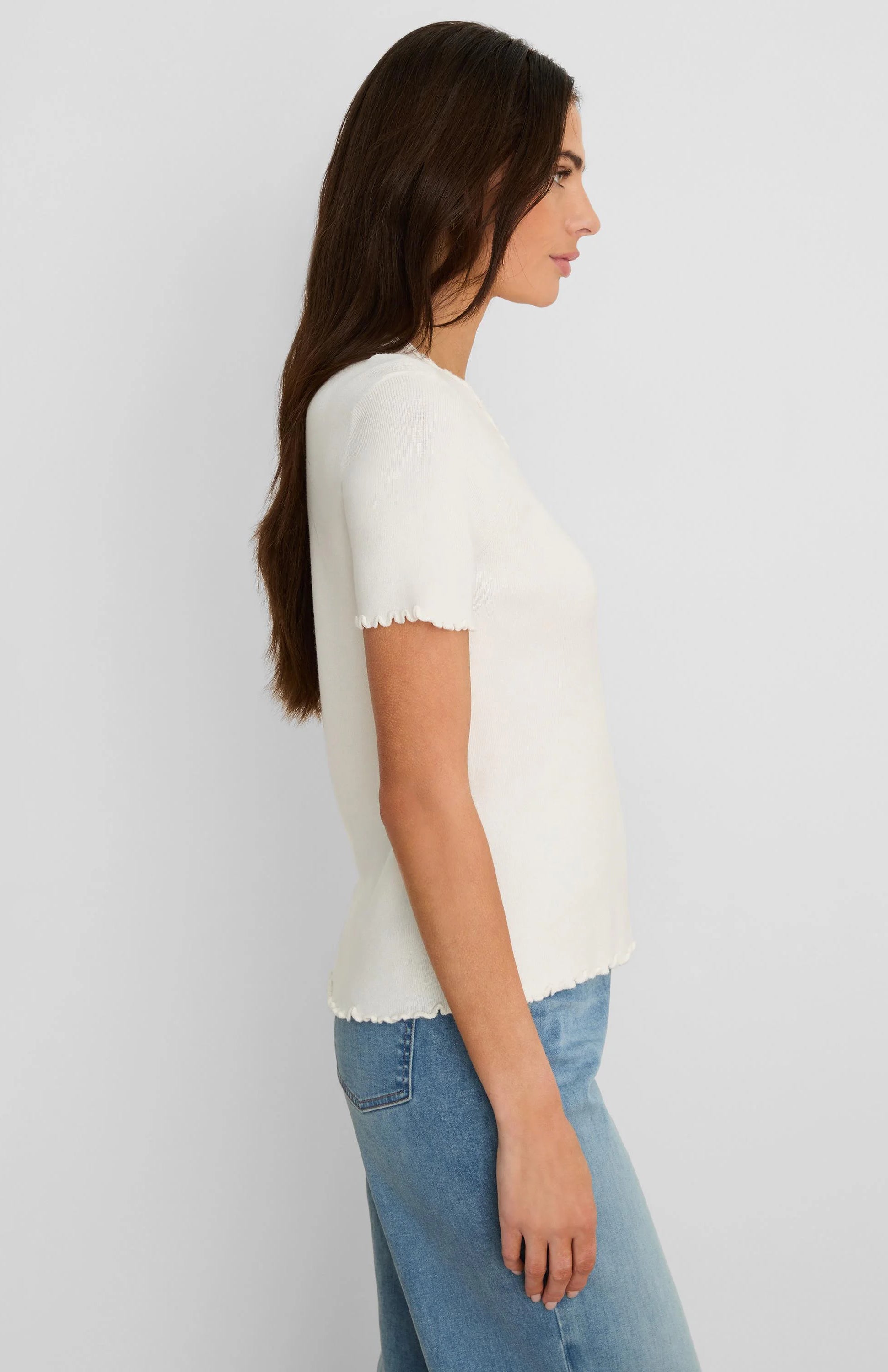Cream ribbed short sleeve top with ruffle trim on the cuffs and hem.