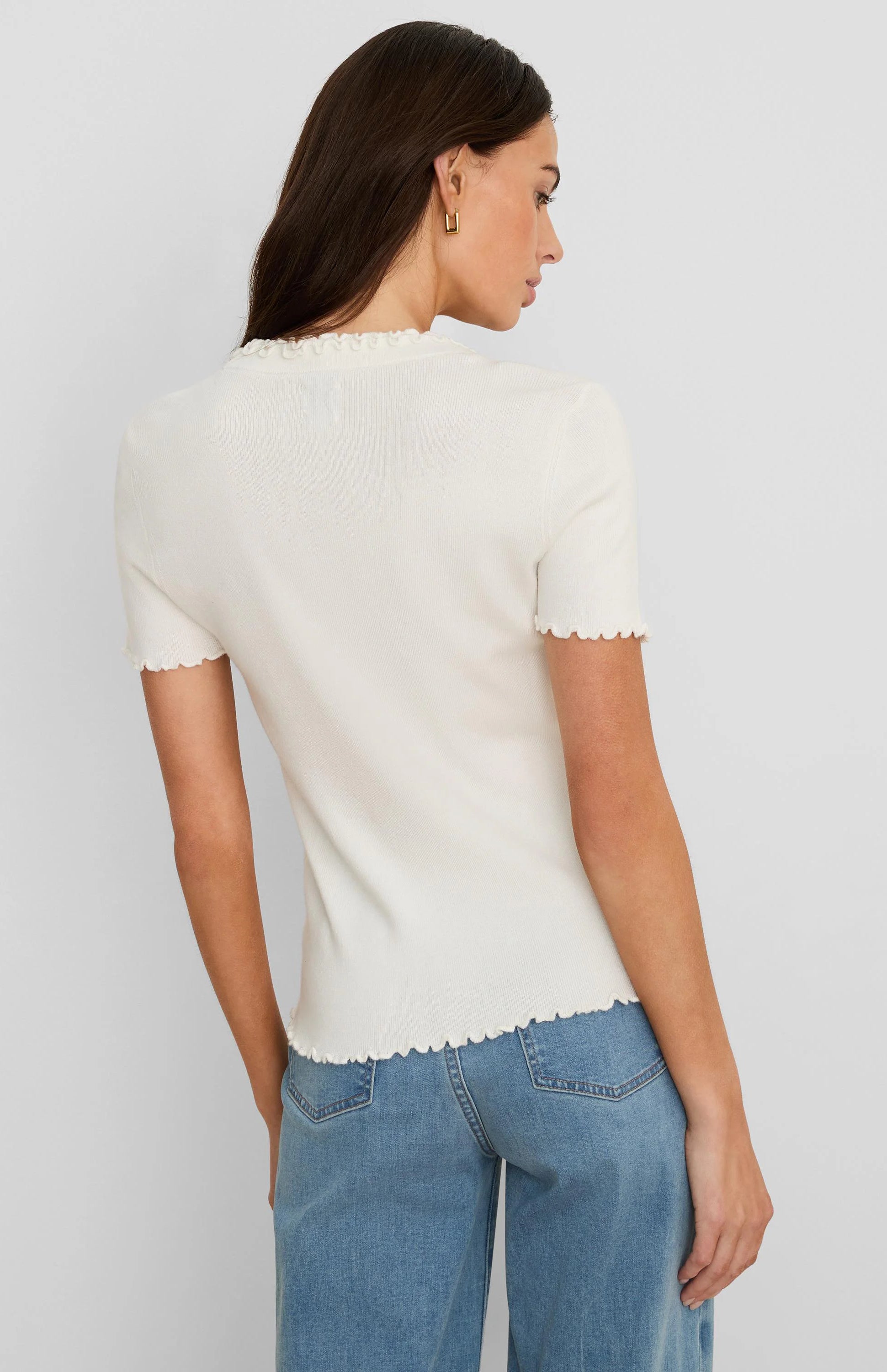 Off-white ribbed short-sleeve tee with ruffles on the high neckline, sleeve cuffs, and bottom hem.
