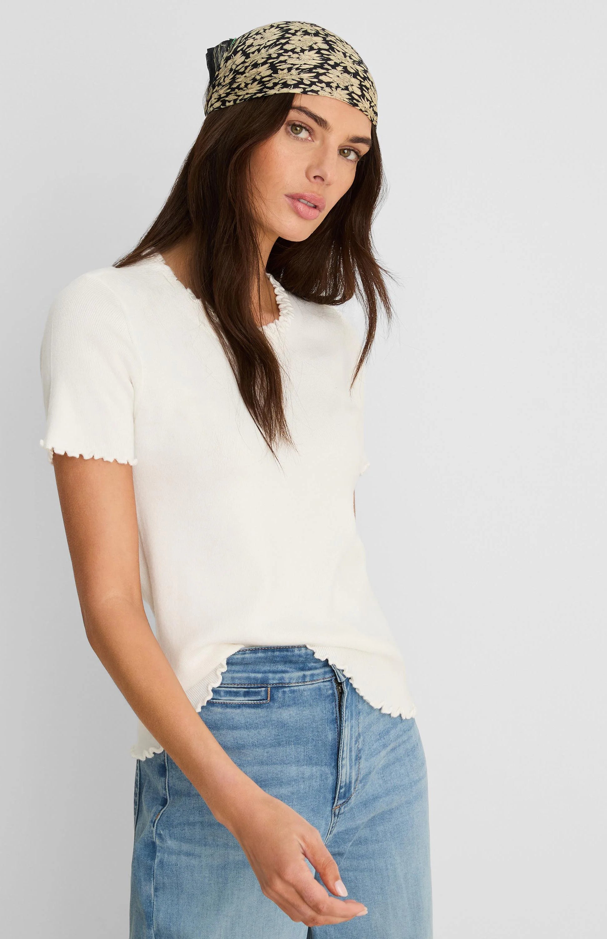 Off-white ribbed short-sleeve tee with ruffle trim at neck, sleeves, and hem.