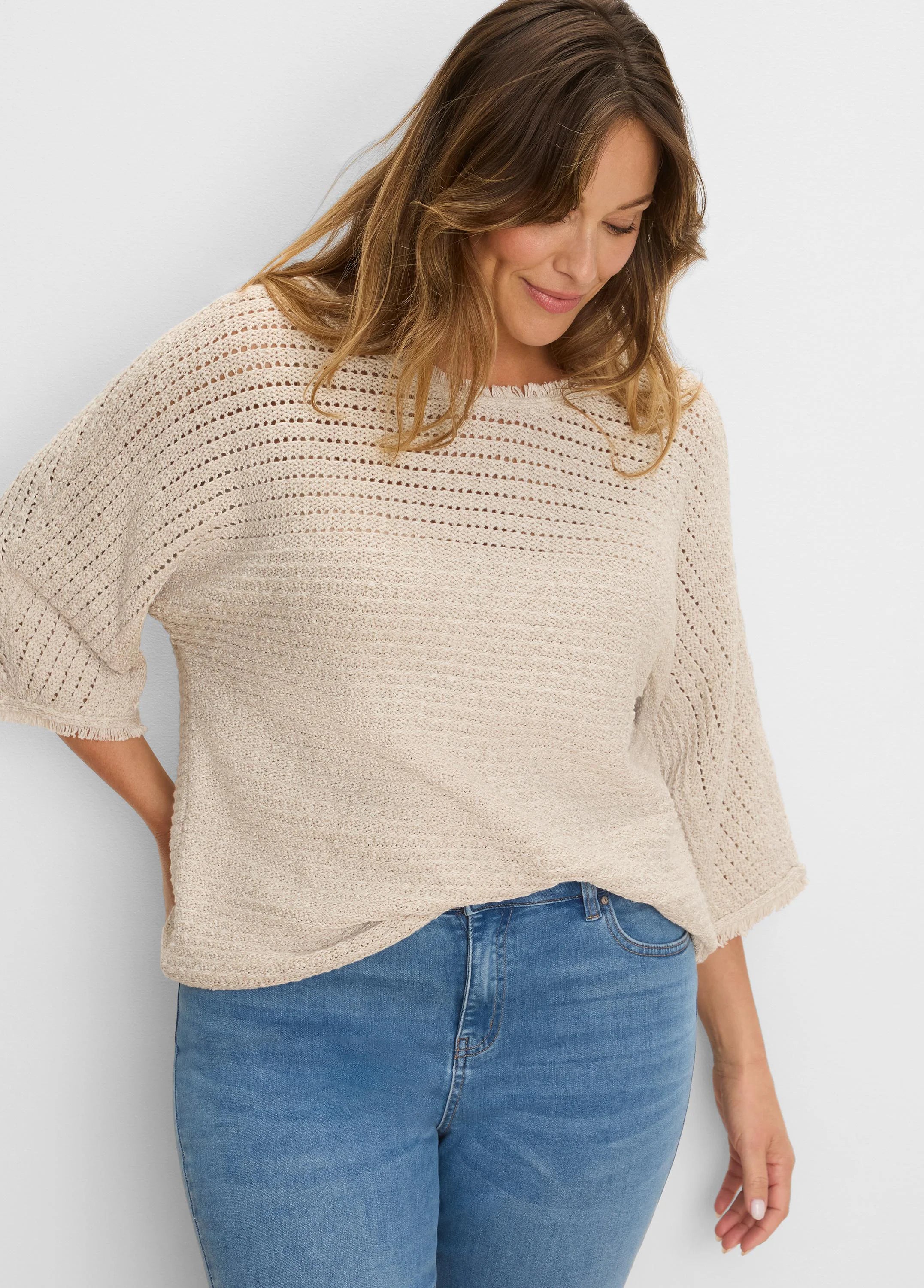 Light beige sweater with varied open-knit upper and dense body, 3/4 sleeves, and fringed edges.