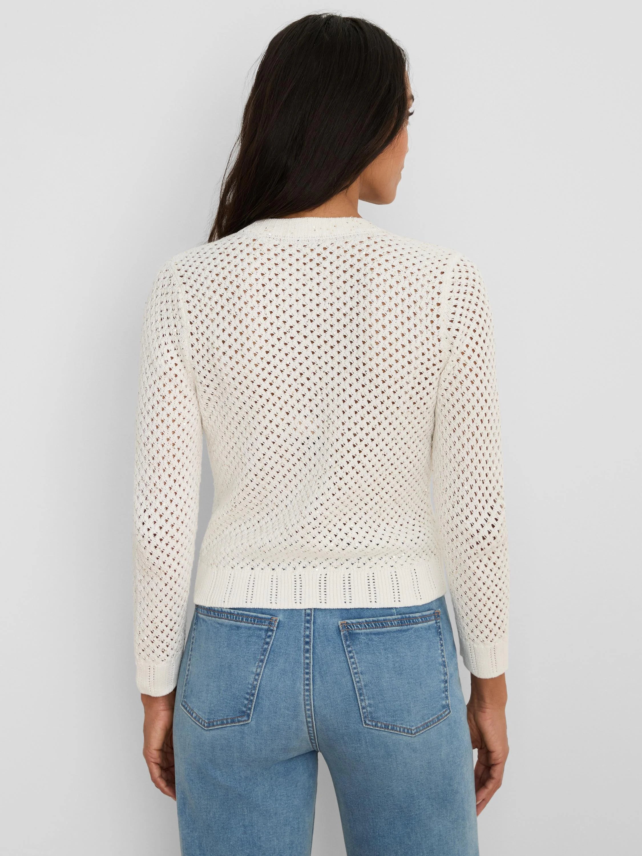 Cream open-knit cardigan with subtle sequins and ribbed trim, back view on model in jeans.