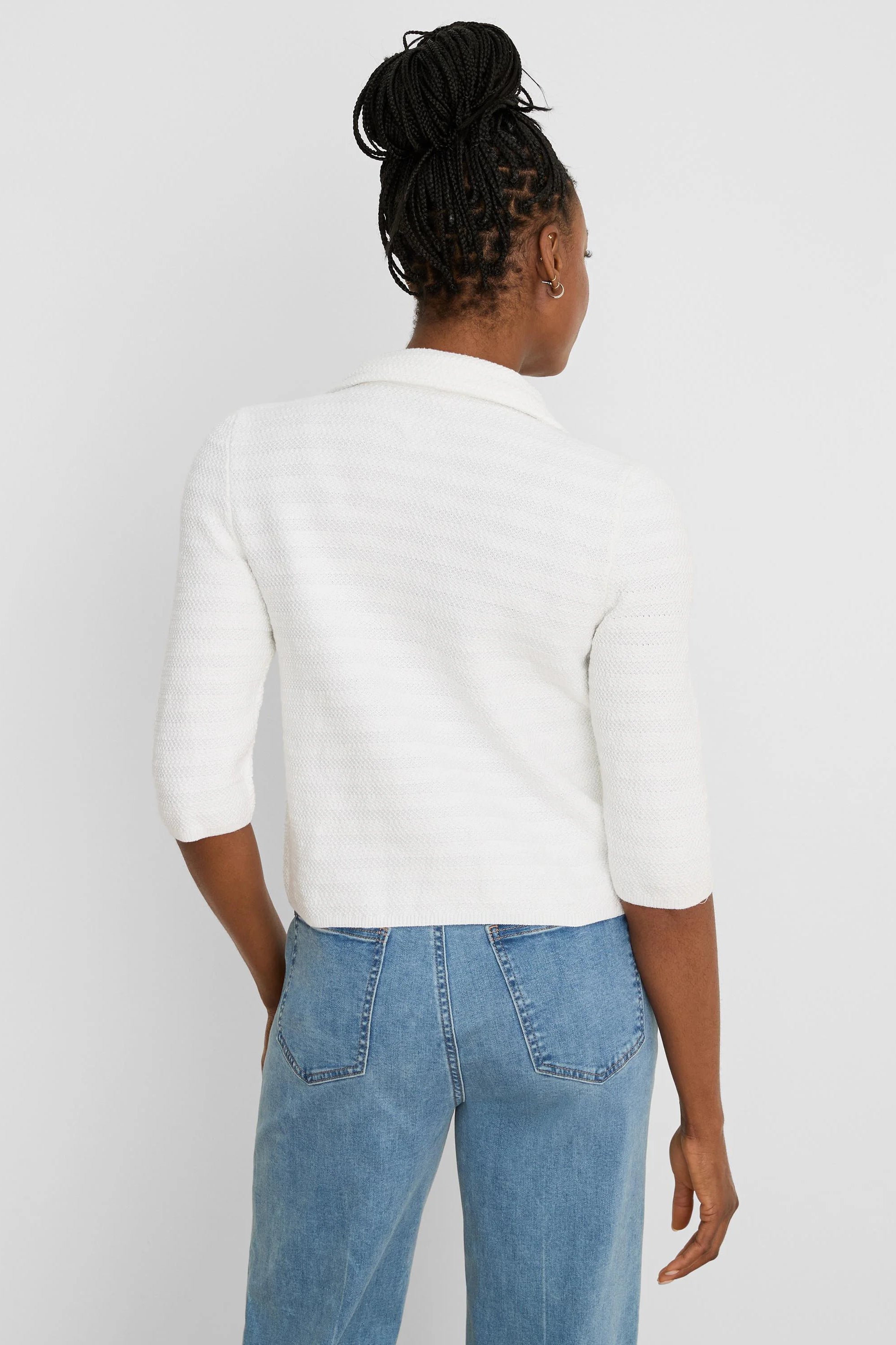 White textured knit jacket with elbow sleeves and collar, worn from behind.