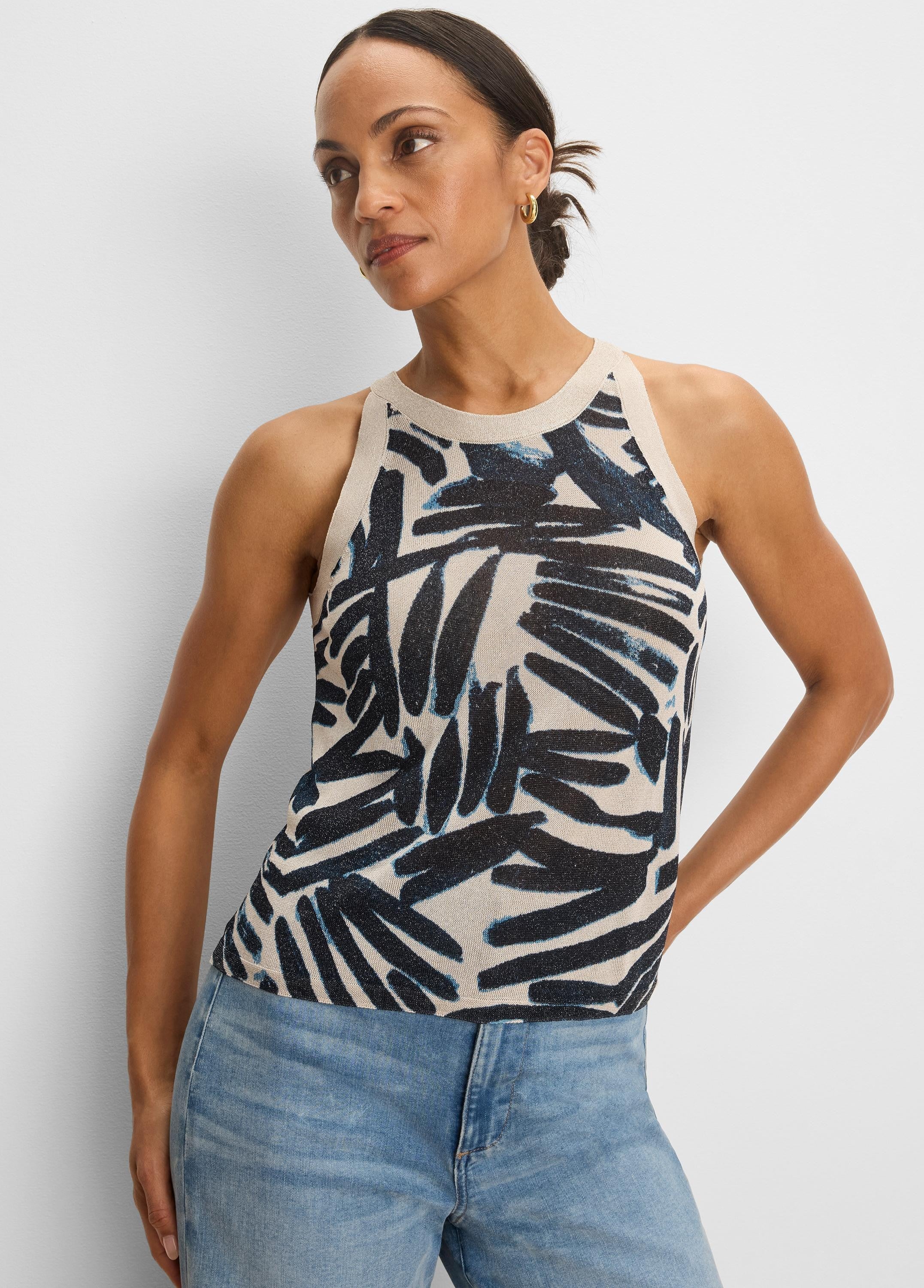 Light beige knit tank with a high neckline. Features an abstract dark blue and light blue palm-like pattern.