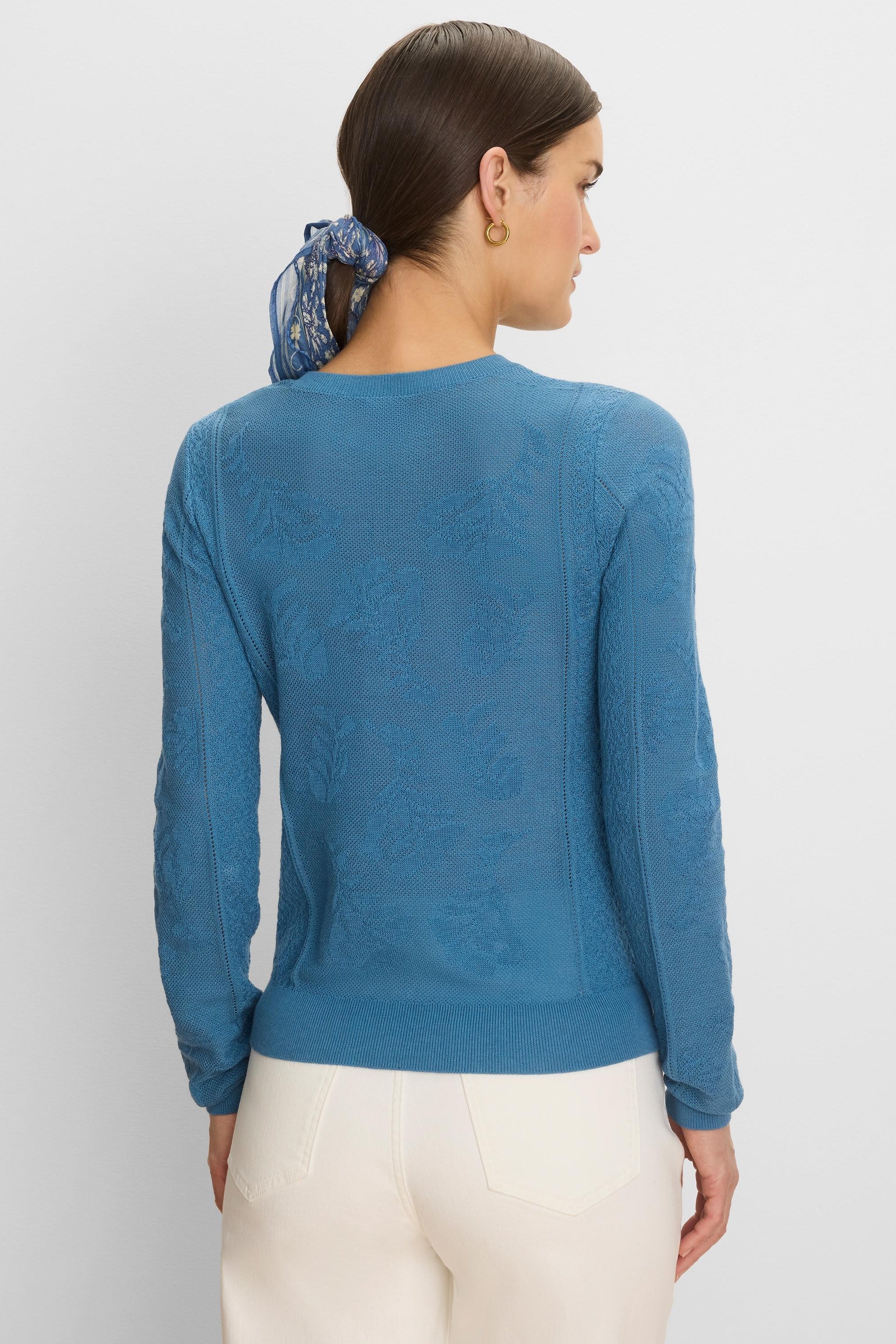 Teal blue long-sleeved jacquard lace sweater with an all-over tonal floral pattern and ribbed trim.