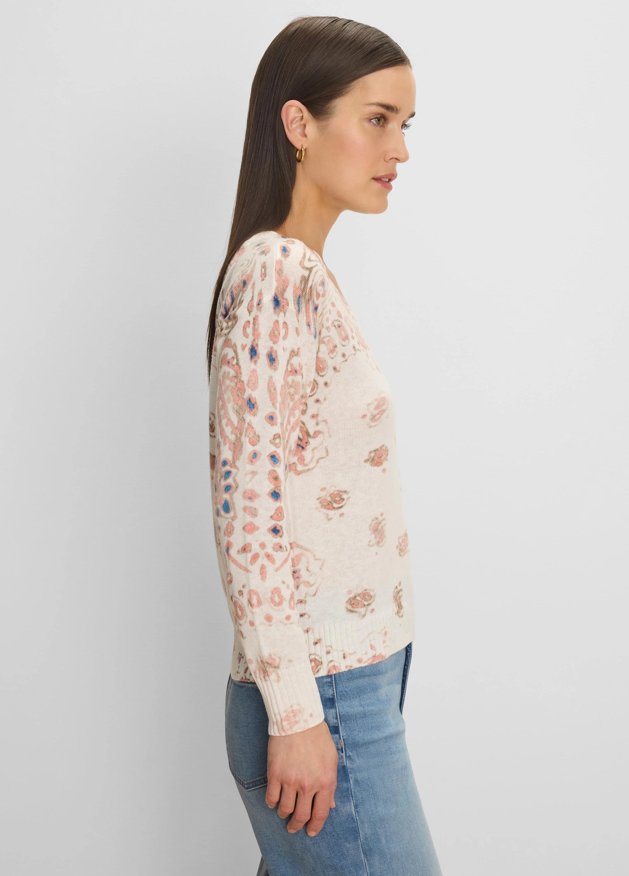 Off-white sweater with scattered pink, brown, and blue paisley pattern.