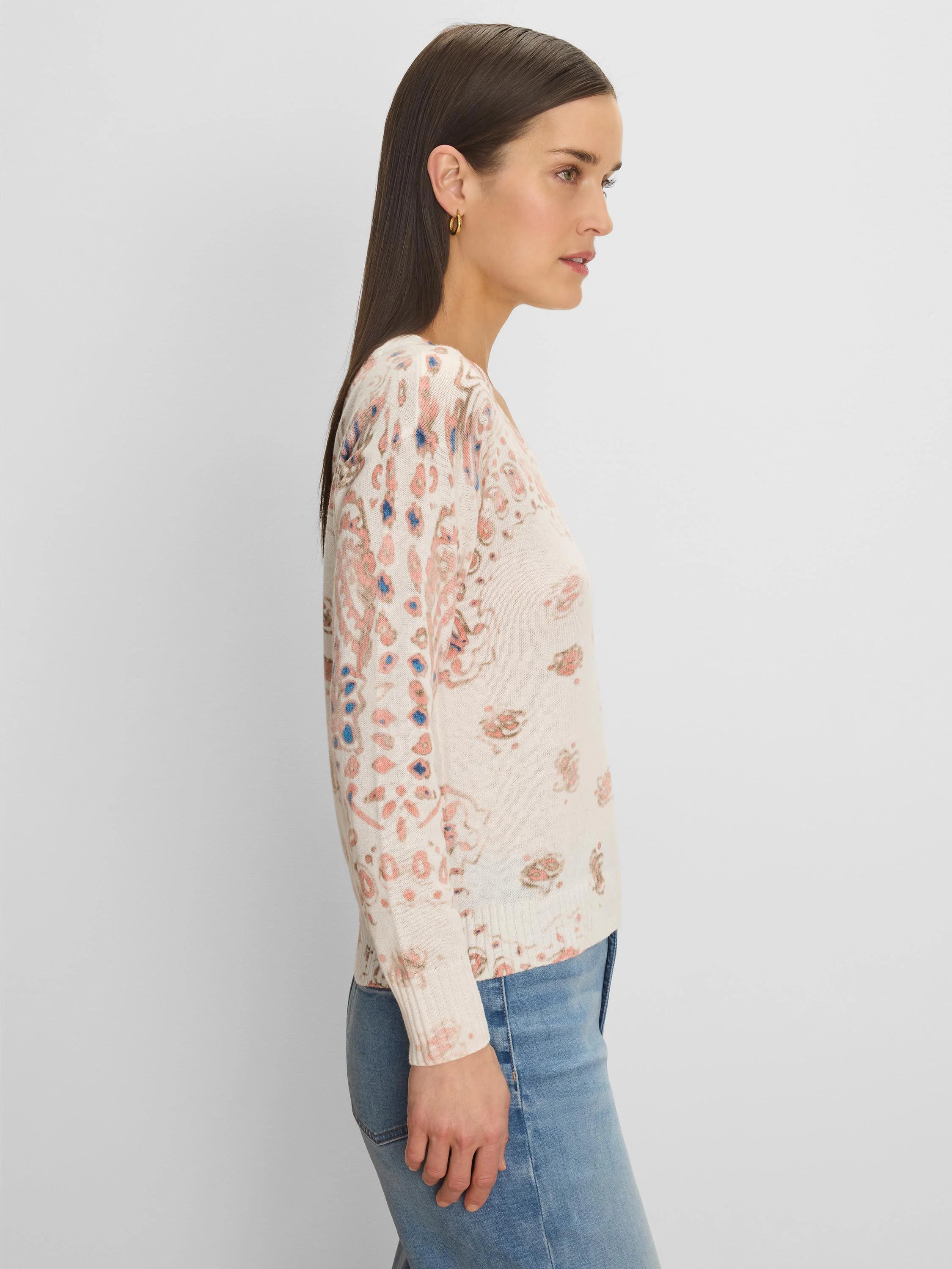 Off-white sweater with scattered pink, brown, and blue paisley pattern.