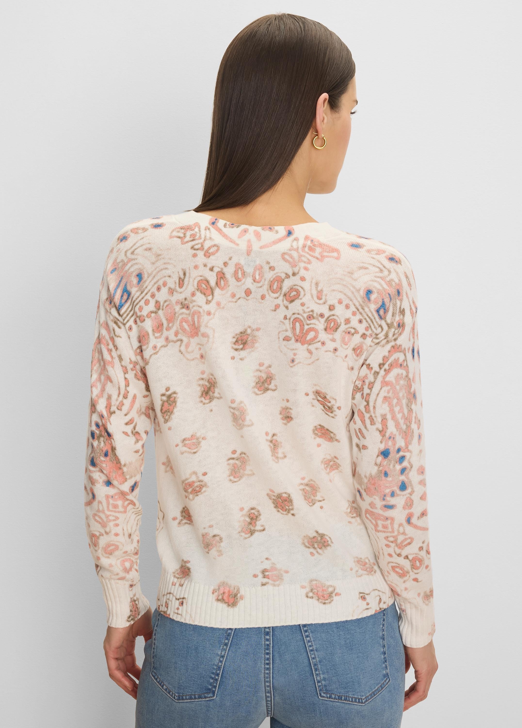 Off-white long-sleeved sweater with peach, blue, and tan paisley pattern, ribbed trim.